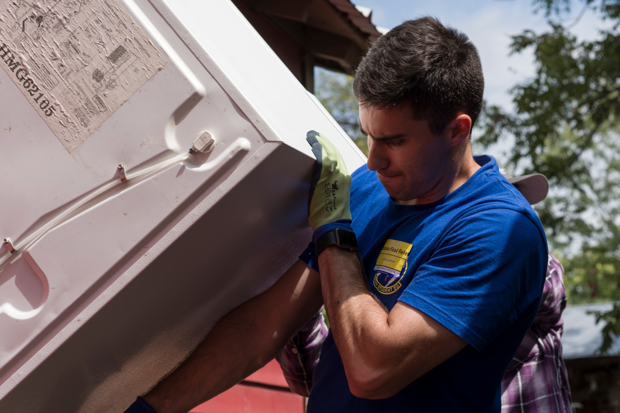 Second Lieutenant Steven Rapphun, 47th Student Squadron student pilot awaiting training, helps remove a flood-damaged refrigerator from a Sonora, Texas, home, Sept. 27, 2018.