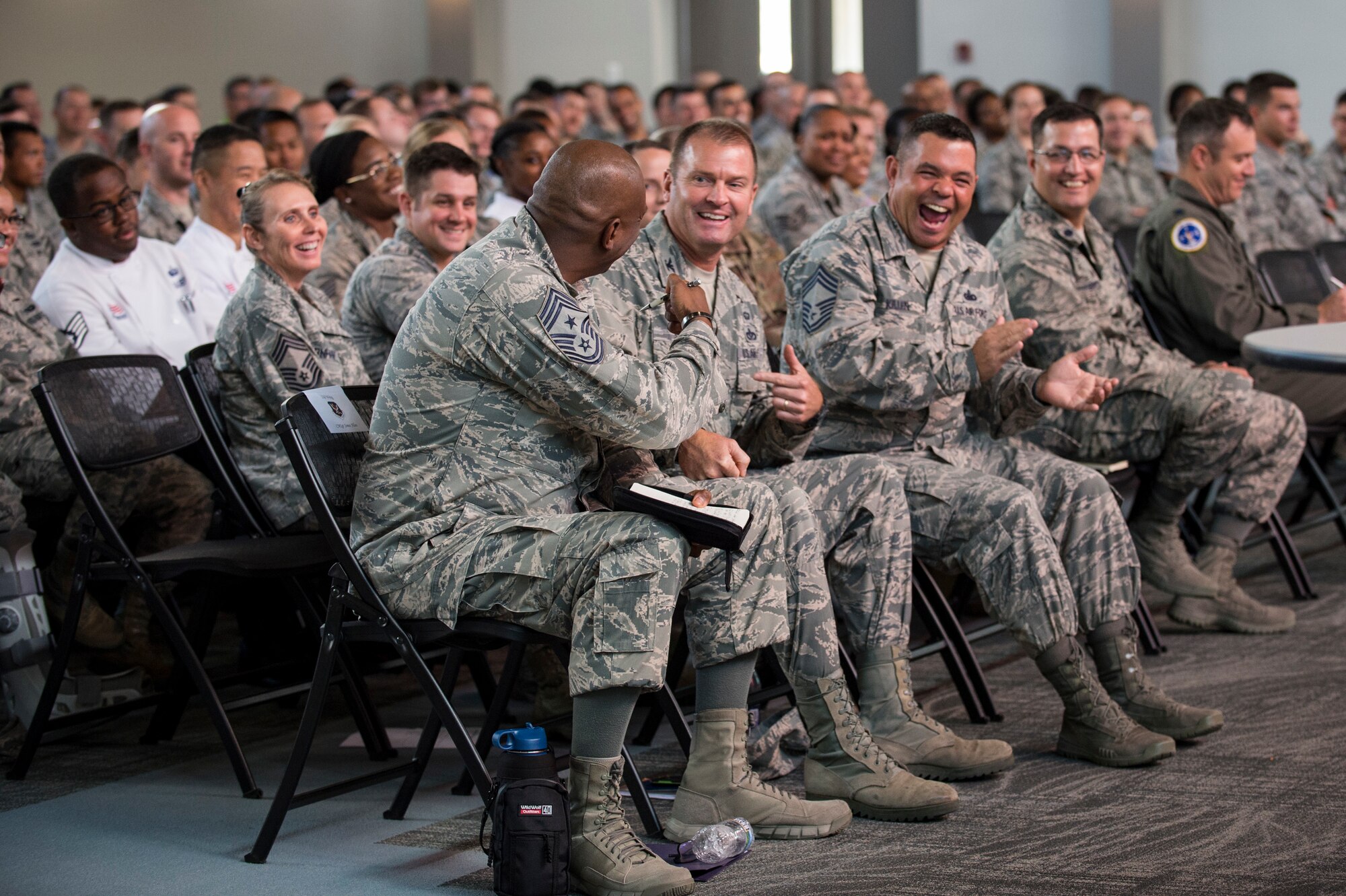 Chief Master Sgt. James Allen, 23d Wing Command Chief, shares a laugh with members of the crowd during a commander’s call, Sept. 24, 2018, at Moody Air Force Base, Ga. During a series of commander’s calls, the 23d Wing commander updated Team Moody on local and national objectives and initiatives, answered Airmen’s questions and highlighted superior performers. (U.S. Air Force photo by Andrea Jenkins)