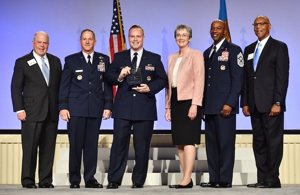 Capt. Michael Kanaan, intelligence, surveillance and reconnaissance enterprise lead receives the Gen. Spencer Innovation Award - Individual from Chief of Staff of the Air Force Gen. David L. Goldfein, second from left, Secretary of the Air Force Heather Wilson, third from right, Chief Master Sgt. of the Air Force Kaleth Wright, second from right, Gen. (ret.) Larry Spencer, far right, and Whit Peters, Chairman of the Air Force Association Board, far left, during the AFA Air, Space and Cyber Conference in National Harbor, Md., Sept. 17, 2018. The award recognizes Kanaan in government, industry and academia as a thought leader in the digital field across all Air Force functions who demonstrably shapes the highest levels of operations, messaging and funding. (U.S. Air Force photo by Staff Sgt. Rusty Frank)