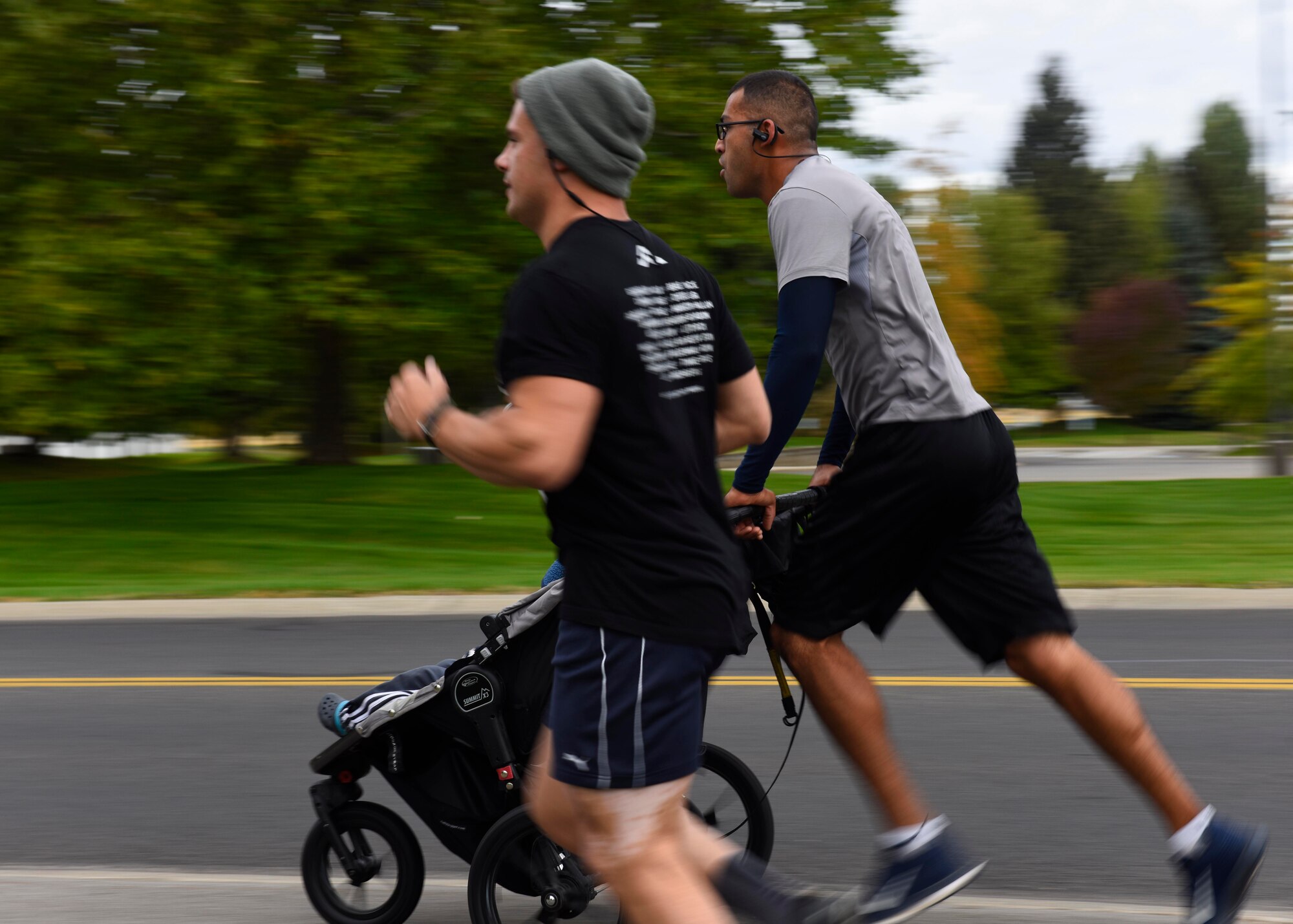 Senior Master Sgt. Jorge Rivera, 92nd Operation Support Squadron air traffic controller, pushes a stroller during the CMSAF Binnicker 9K Memorial Run at Millier Park in Farichild Air Force Base, Washington, Sept. 22, 2018. Participants of the run received a finisher's medallion as well as a commemorative event challenge coin. (U.S. Air Force photo/Airman 1st Class Lawrence Sena)