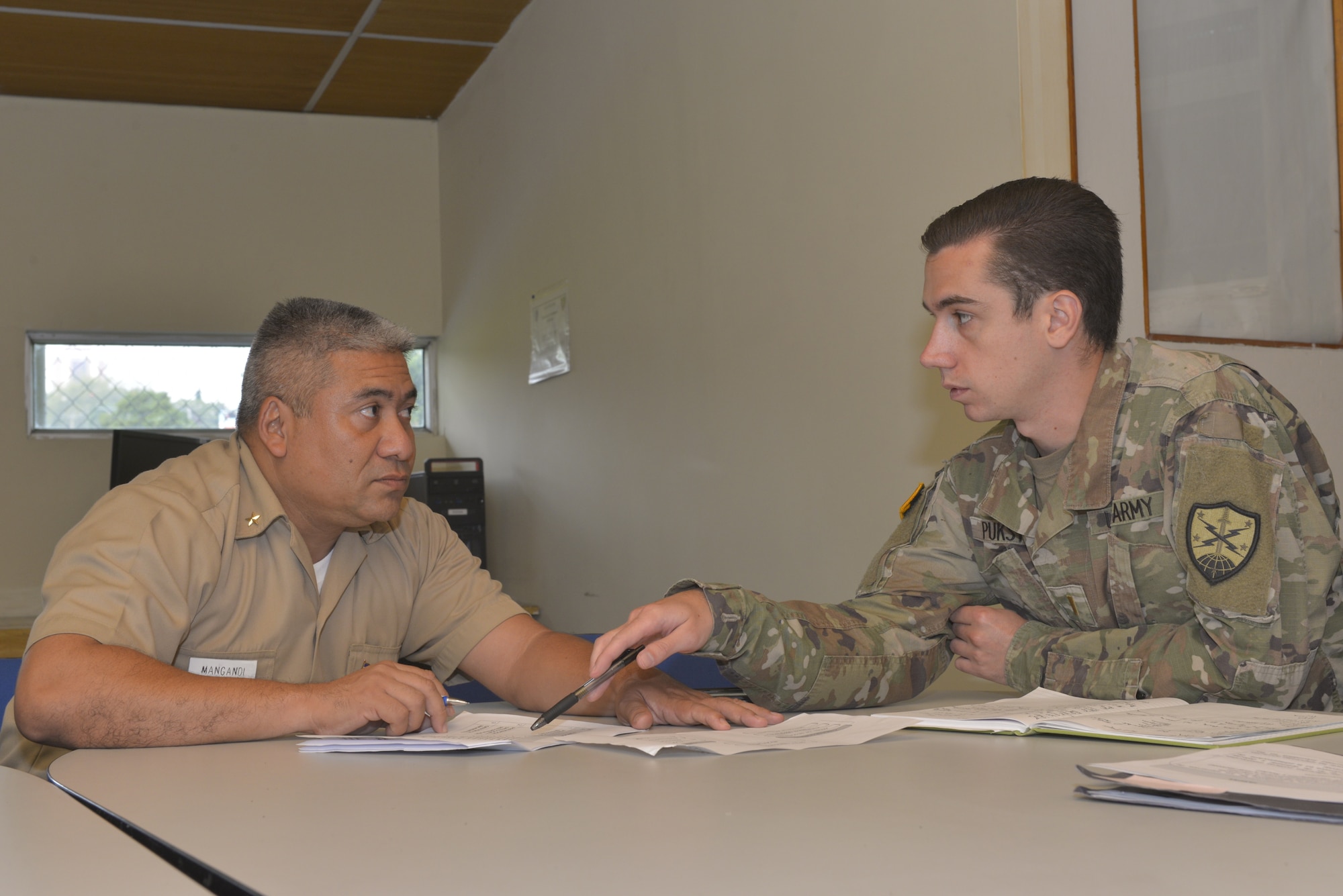 A New Hampshire Army National Guard Soldier speaks with a Salvadoran navy officer.