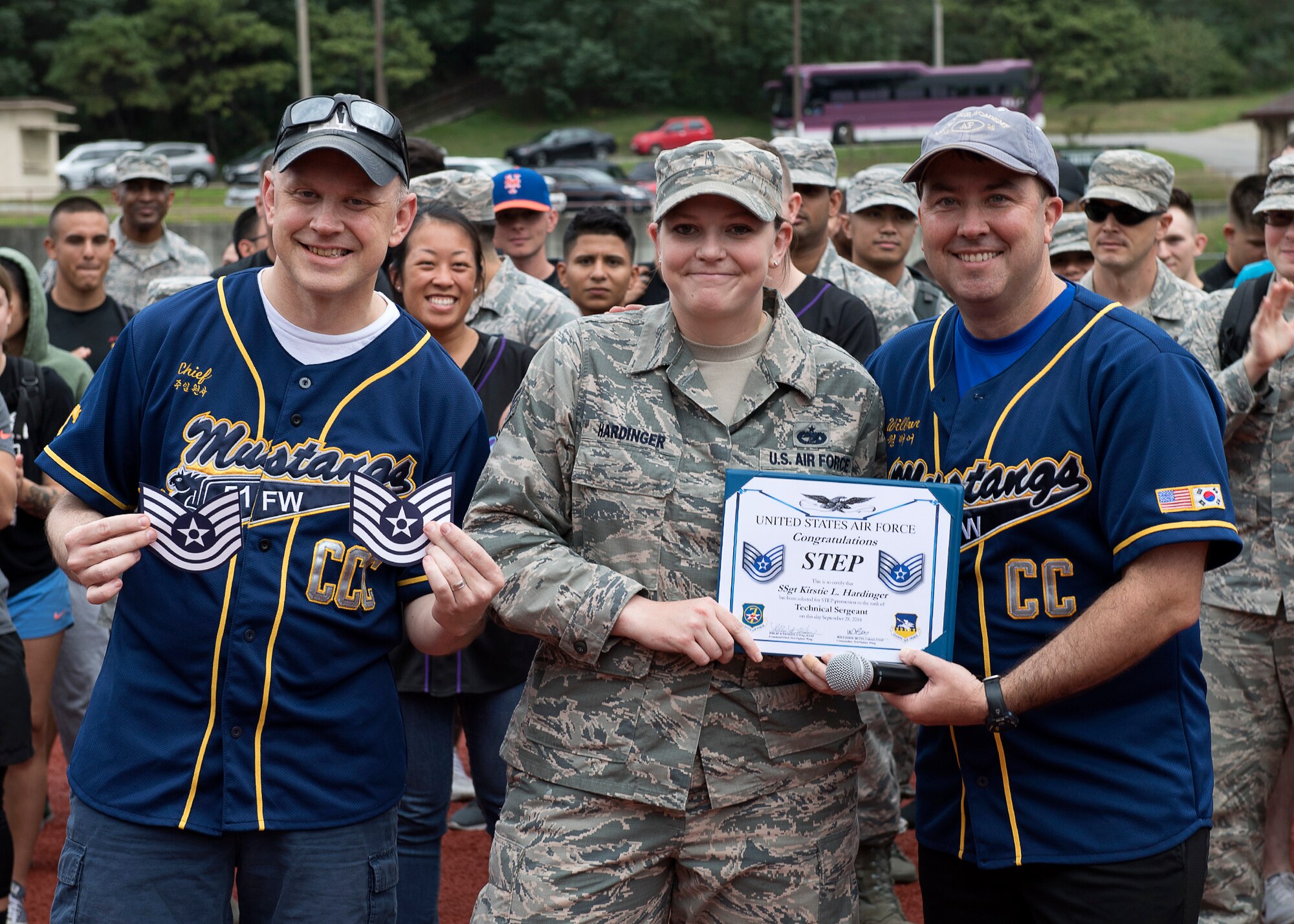 U.S. Air Force Staff Sgt. Kristie Hardinger, center, with the 51st Logistics Readiness Squadron, receives a certificate of promotion from Col. William Betts, right, 51st Fighter Wing commander, at Osan Air Base, Republic of Korea, Sept. 28, 2018. Hardinger was promoted to technical sergeant thorough the Stripes to Exceptional Performers program. (U.S. Air Force photo by Staff Sgt. Sergio A. Gamboa)
