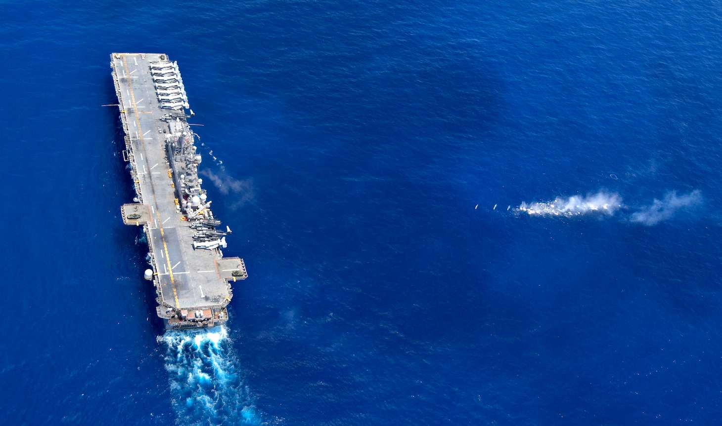 SOUTH CHINA SEA (Sept. 27, 2018) - The amphibious assault ship USS Wasp (LHD 1) performs maneuvers as Sailors and Marines, assigned to the 31st Marine Expeditionary Unit (MEU), fire weapons, including Light Armored Vehicles, at a target during a Defense of the Amphibious Task Force (DATF) drill. As part of the DATF, the Wasp Amphibious Ready Group (ARG), 31st MEU team, assumed a security posture, to simulate traveling through potentially dangerous waters. Wasp, flagship of the Wasp ARG, with embarked 31st MEU, is operating in the Indo-Pacific region to enhance interoperability with partners and serve as a ready-response force for any type of contingency.