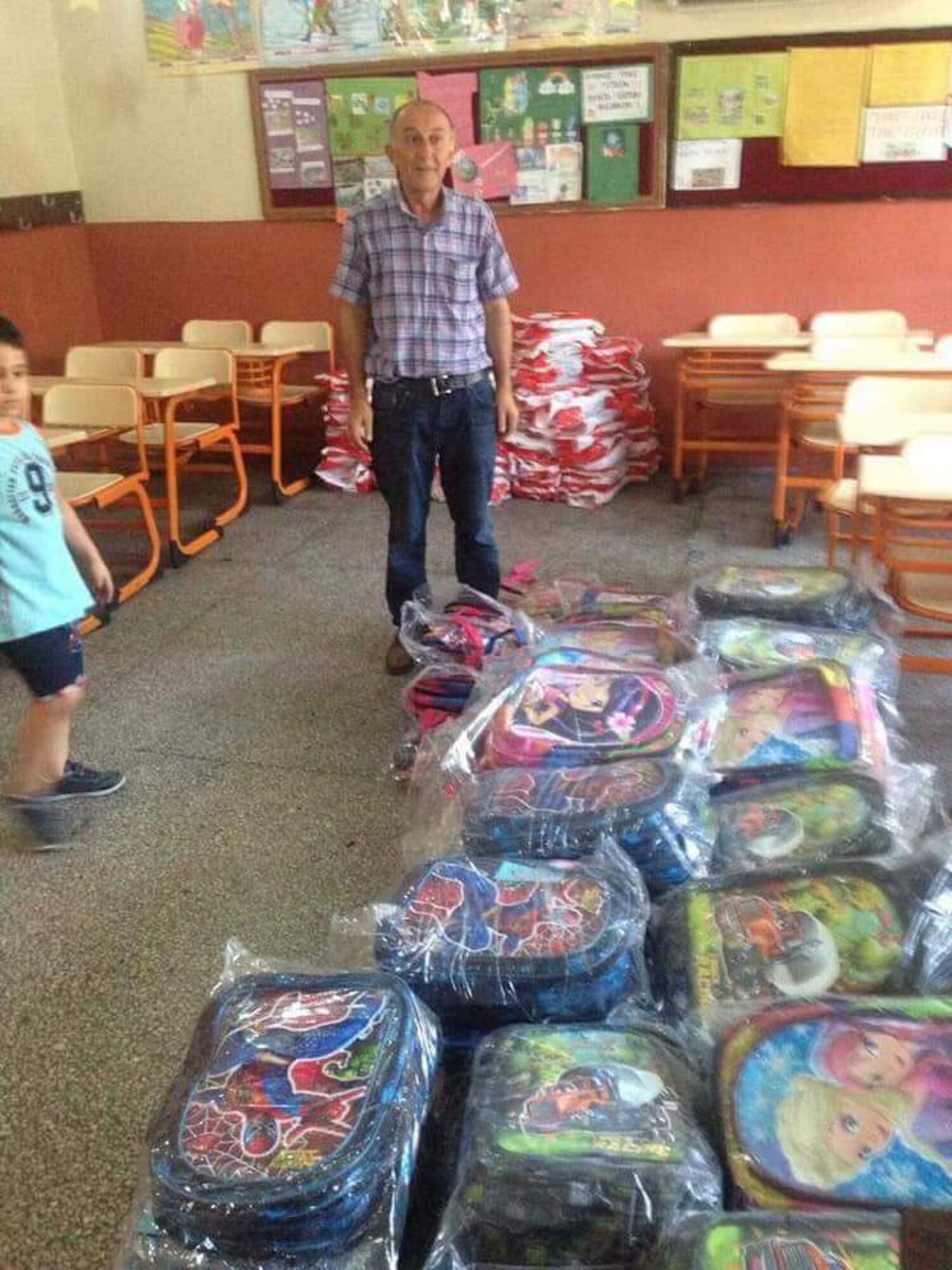 A teacher at Necmiye CoskunTuncel Ilkokulu Primary School receives backpacks and other school supplies for local Turkish students before the first day of school in Adana, Turkey.