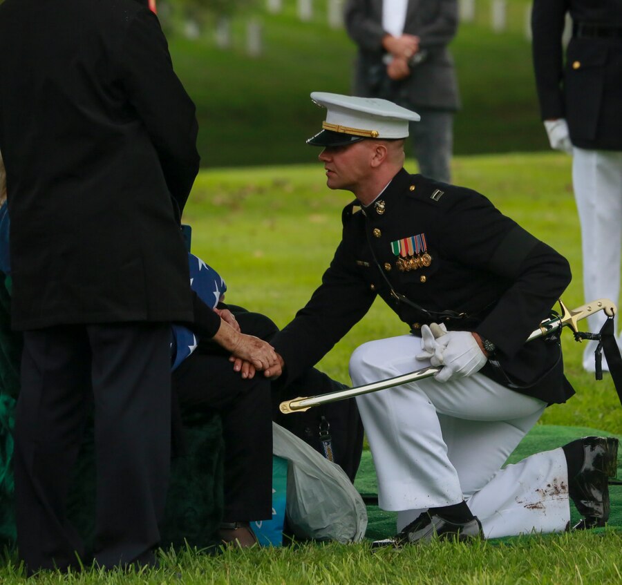 Captain Mason W. Graham, platoon commander, 2nd platoon, Bravo Company, Marine Barracks Washington D.C., speaks with the next of kin during a full honors funeral for three formerly unaccounted for Vietnam veterans at Arlington National Cemetery, Arlington, Va., Sept. 27, 2018. Capt. John A. House II, Cpl. Glyn L. Runnels, Jr. and Lance Cpl. John D. Killen III were accounted for on Dec. 22, 2015 and buried together in Arlington. The Marines died when their CH-64A Sea Knight helicopter was struck by enemy fire and crashed, June 30, 1967. House, who piloted the helicopter, was attempting to insert eight members of Company A, 3rd Reconnaissance Battalion, 3rd Marine Division, into hostile territory in Thau Thien-Hue Province, Vietnam, when enemy forces attacked from a surrounding tree line. Lance Cpl. Merlin R. Allen and Navy Hospital Corpsman Michael B. Judd also died during the crash and were individually identified in 2013. (U.S. Marine Corps photo by Sgt. Robert Knapp/Released)