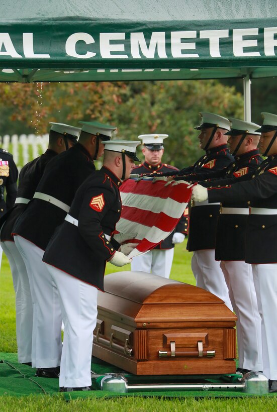 Marine Corps Body Bearers, Bravo Company, Marine Barracks Washington D.C., fold the National Flag during a full honors funeral for three formerly unaccounted for Vietnam veterans at Arlington National Cemetery, Arlington, Va., Sept. 27, 2018.