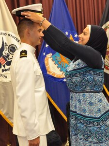 IMAGE: DAHLGREN, Va. (Sept. 11, 2018) – Nourhan Ibrahim places a new officer’s cover on the head of her husband, Dillard Patton, who was commissioned into the Naval reserves as an ensign at a ceremony held at the Aegis Training and Readiness Center. Ensign Patton - an NSWCDD System Safety Engineering Division civilian engineer – expressed a special appreciation to his family during the ceremony. “Without your support, I wouldn’t be standing where I am today,” said Patton. “You have stood by my side through my best and my worst, but in all instances you motivated me to give it my all and succeed.”