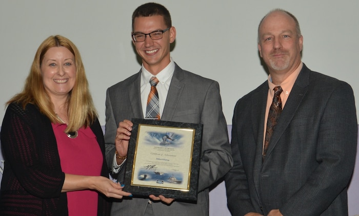 IMAGE: DAHLGREN, Va. (Sept. 21, 2018) – Dillard Patton receives his certificate of achievement from Naval Surface Warfare Center Dahlgren Division (NSWCDD) Acting Chief of Staff Terri Gray and Acting Deputy Technical Director Chris Clifford at the 2018 NSWCDD Academic Recognition Ceremony. Patton –  commissioned into the Naval Reserves ten days earlier – was recognized for completing his master's degree in systems engineering from Old Dominion University, and commended for his commitment to personal and professional development.