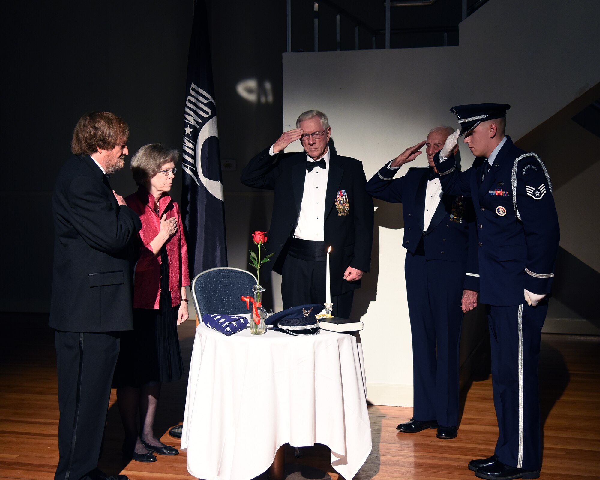 Community members, former prisoners of war and a Columbus Air Force Base Honor Guard ceremonial guardsman pay their respects to POWs and those missing in action during the 2018 Air Force Ball Sept. 22, 2018, in Columbus, Mississippi. At official Air Force ceremonies, a table is left open for service members who were captured or never came back home. (U.S. Air Force photo by Sharon Ybarra)