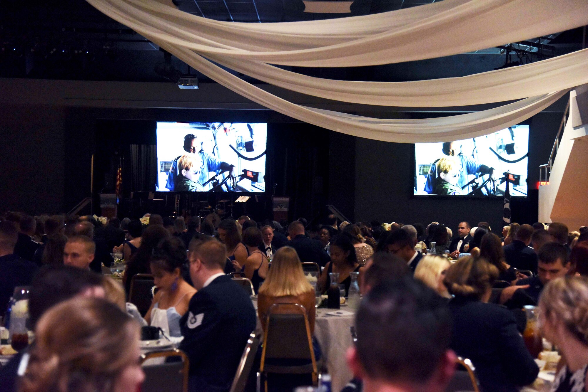 Columbus Air Force Base personnel and the local community watch a video during the 2018 Air Force Birthday Ball Sept. 22, 2018, in Columbus, Mississippi. The video highlighted the strong partnership the base and the community has had for 77 years. (U.S. Air Force photo by Sharon Ybarra)