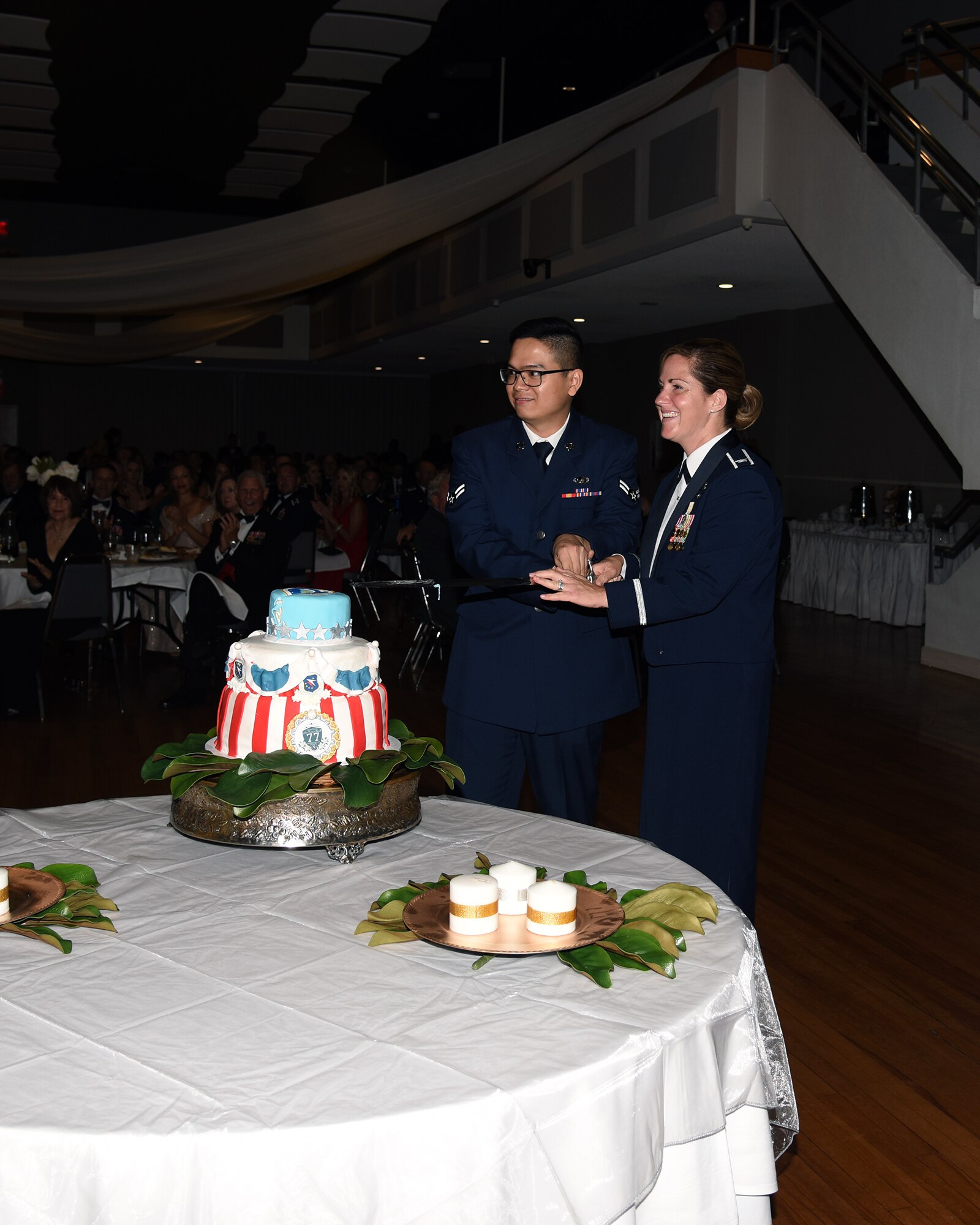 Col. Samantha Weeks, 14th Flying Training Wing commander, and Airman 1st Class Arvin Dizon, 14th Comptroller Squadron financial operations technician, prepare to cut the cake during the 2018 Air Force Birthday Ball Sept. 22, 2018, in Columbus, Mississippi. The highest and the lowest ranking members in attendance were responsible for cutting the birthday cake. (U.S. Air Force photo by Sharon Ybarra)