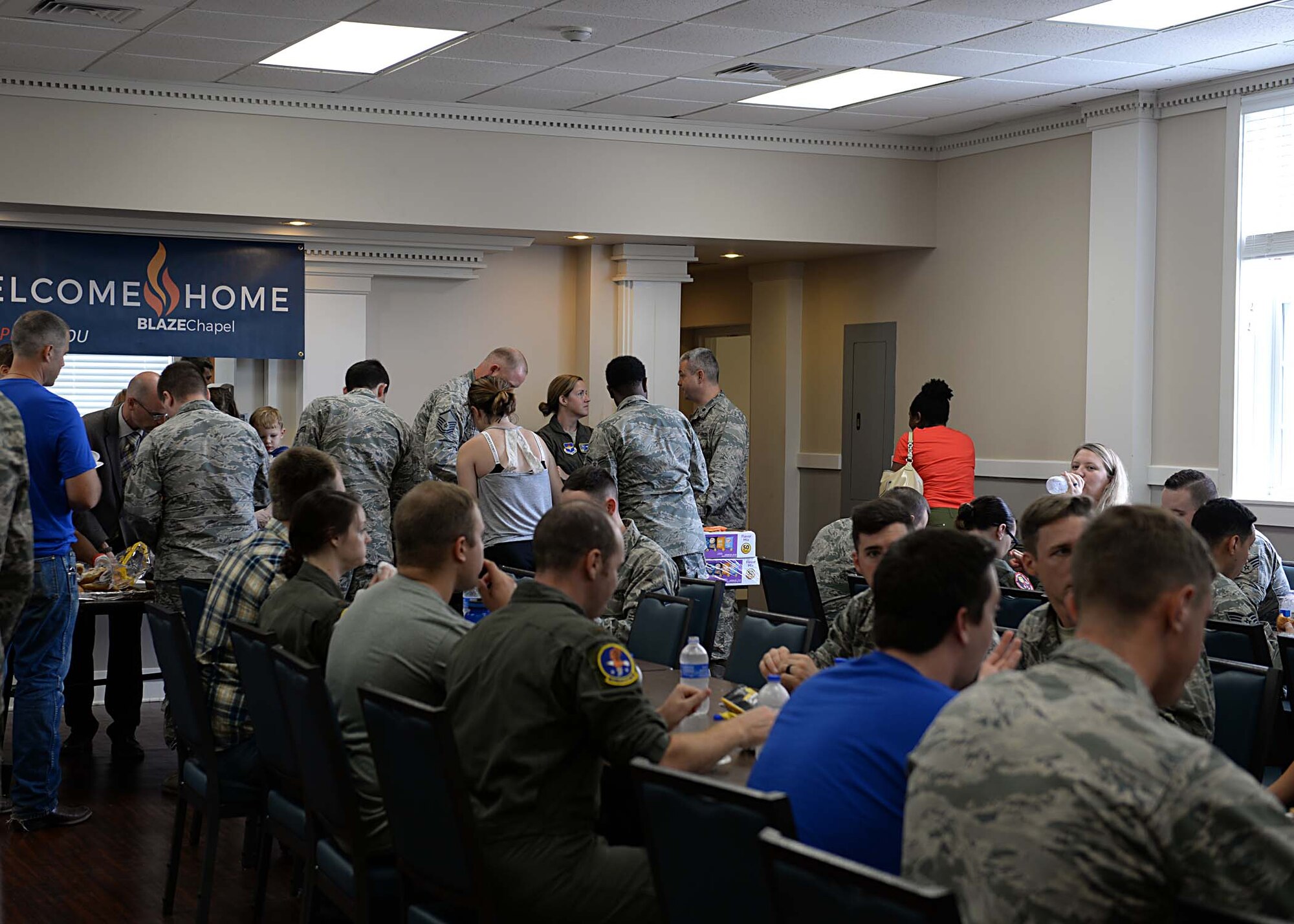 People gather in the chapel annex after the BLAZE Chapel re-opening ceremony Sept. 25, 2018, at Columbus Air Force Base, Mississippi. The BLAZE Chapel provided food to attendees as part of the “Welcome Home” theme. (U.S. Air Force photo by Airman Hannah Bean)