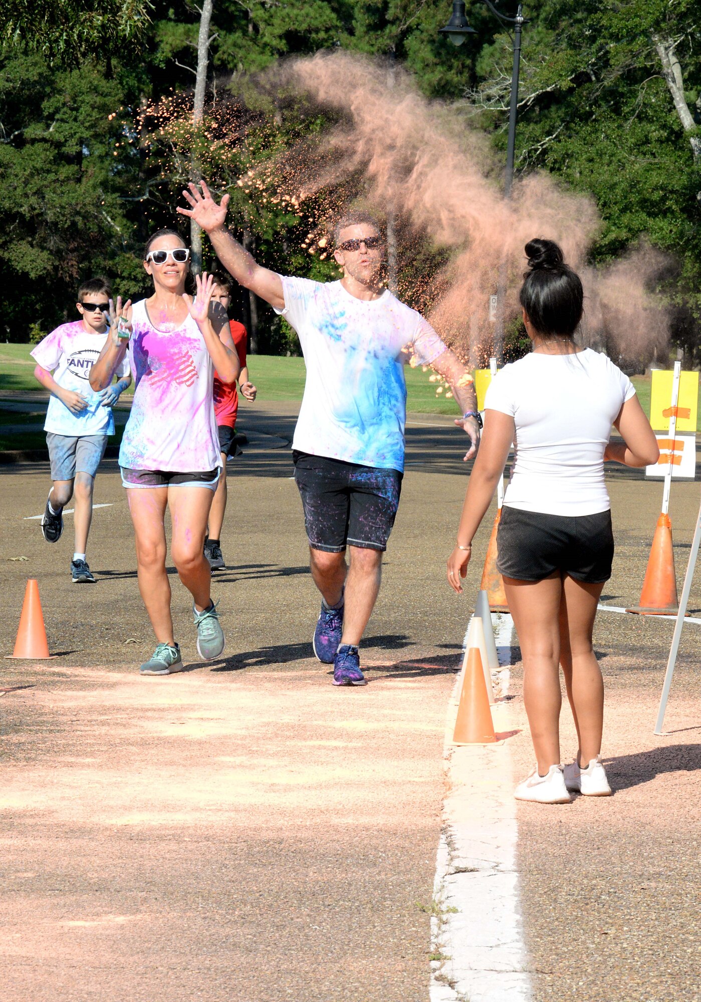 Volunteers  throw different colors of chalk toward runners during the sixth annual color run Sept. 22, 2018, at Columbus Air Force Base, Mississippi. The 14th Force Support Squadron Youth Center hosted the Color Run as fun way for Airmen to be healthy and stay fit.  (U.S. Air Force photo by Airman Hannah Bean)