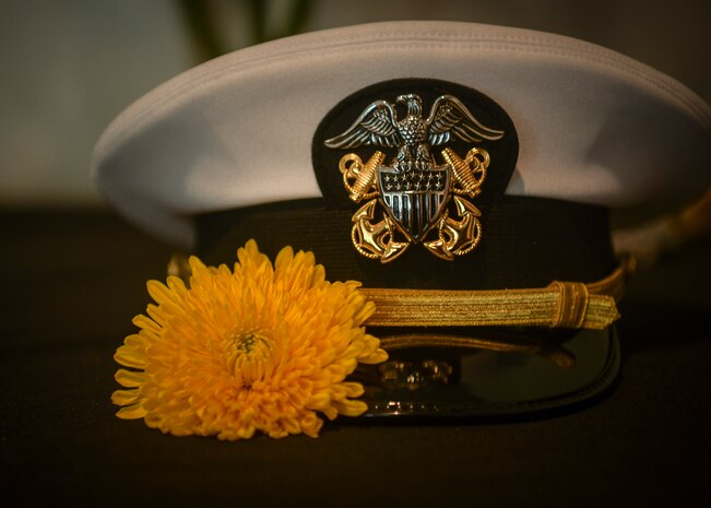 A yellow flower, signifying remembrance, rests next to a naval dress cap during the Bells Across America memorial ceremony Sept. 27, 2018, at Joint Base Charleston, S.C. The ceremony is an annual U.S. military tradition held across the country to honor and commemorate fallen service members. During the ceremony, a bell is rung after each service member’s name is read.