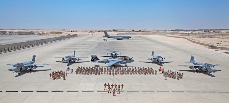 Marines deployed with Marine Tactical Electronic Warfare Squadron 2 pose for a group photo on the ramp at Al Udeid Air Base, Qatar, Aug. 16, 2018. Marines with VMAQ-2 are taking part in the final EA-6B Prowler deployment before the final six aircraft in the U.S. military inventory are retired. (U.S. Army photo by Spc. Jose Diaz/Released)