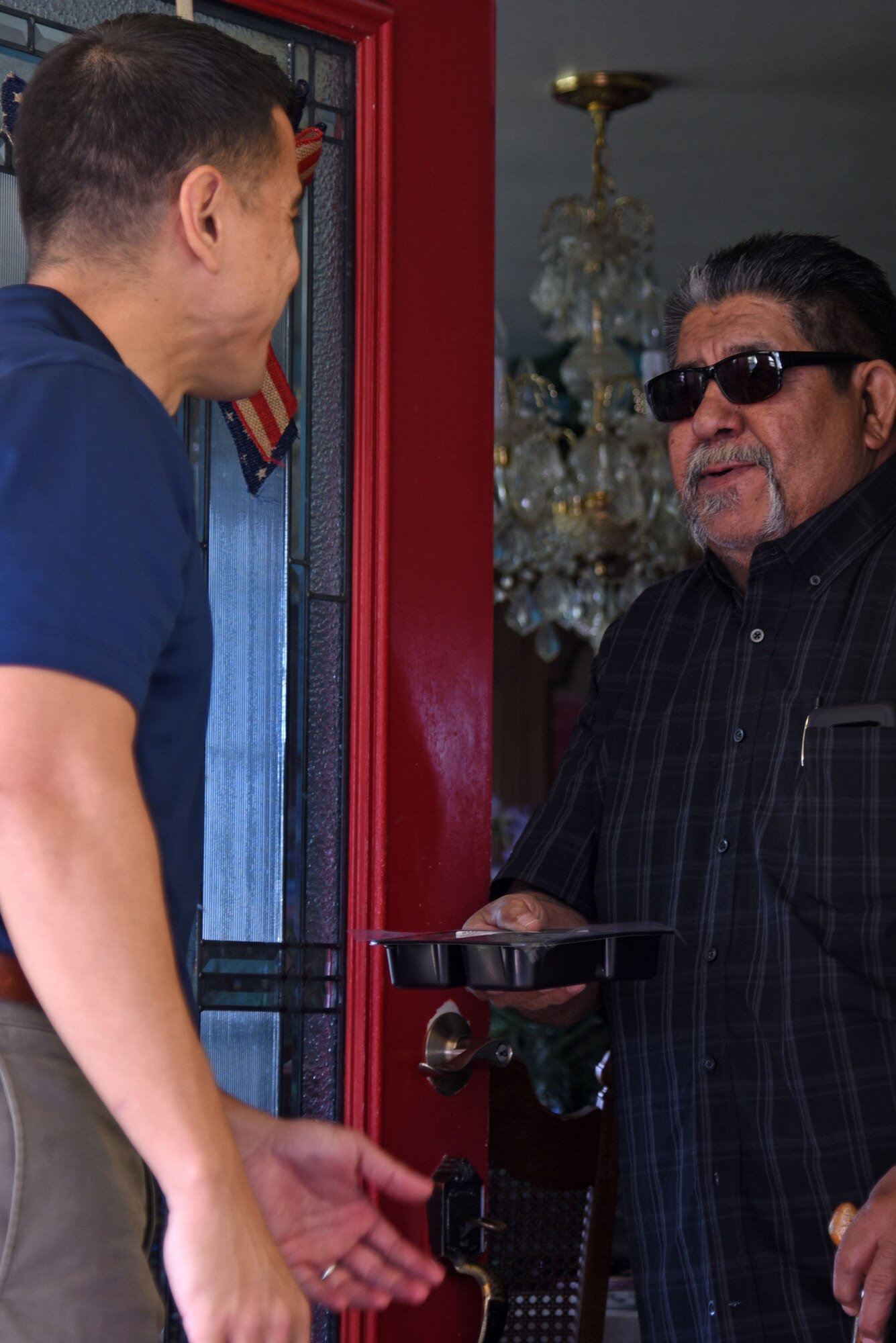 U.S. Air Force Col. Ricky Mills, 17th Training Wing commander, gives a meal to Roberto Canava for the Meals for the Elderly program at Canava’s house in San Angelo, Texas, Sept. 27, 2018. Mills and other community leaders came together to help provide elderly members of San Angelo with food and to perform wellness checks. (U.S. Air Force photo by Staff Sgt. Joshua Edwards/Released)