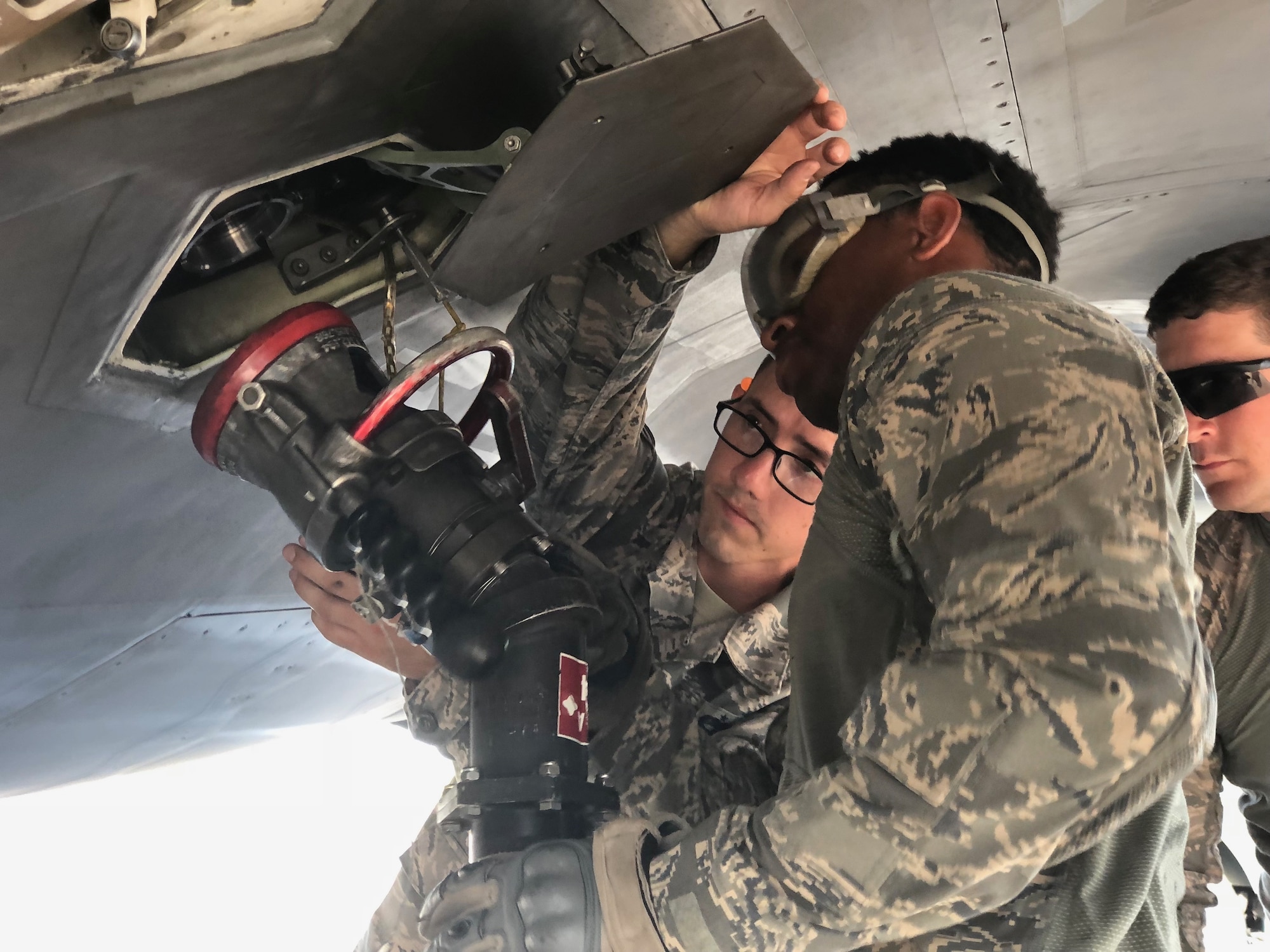 Staff Sgt. Cedric Koonce, assigned to the 78th Security Forces Squadron at Robins Air Force Base, Georgia, along with two other Airmen get the fuel hose lined up for refueling an F-22 Raptor during the Combat Support Wing Exercise 18 September at Moody Air Force Base, Georgia.