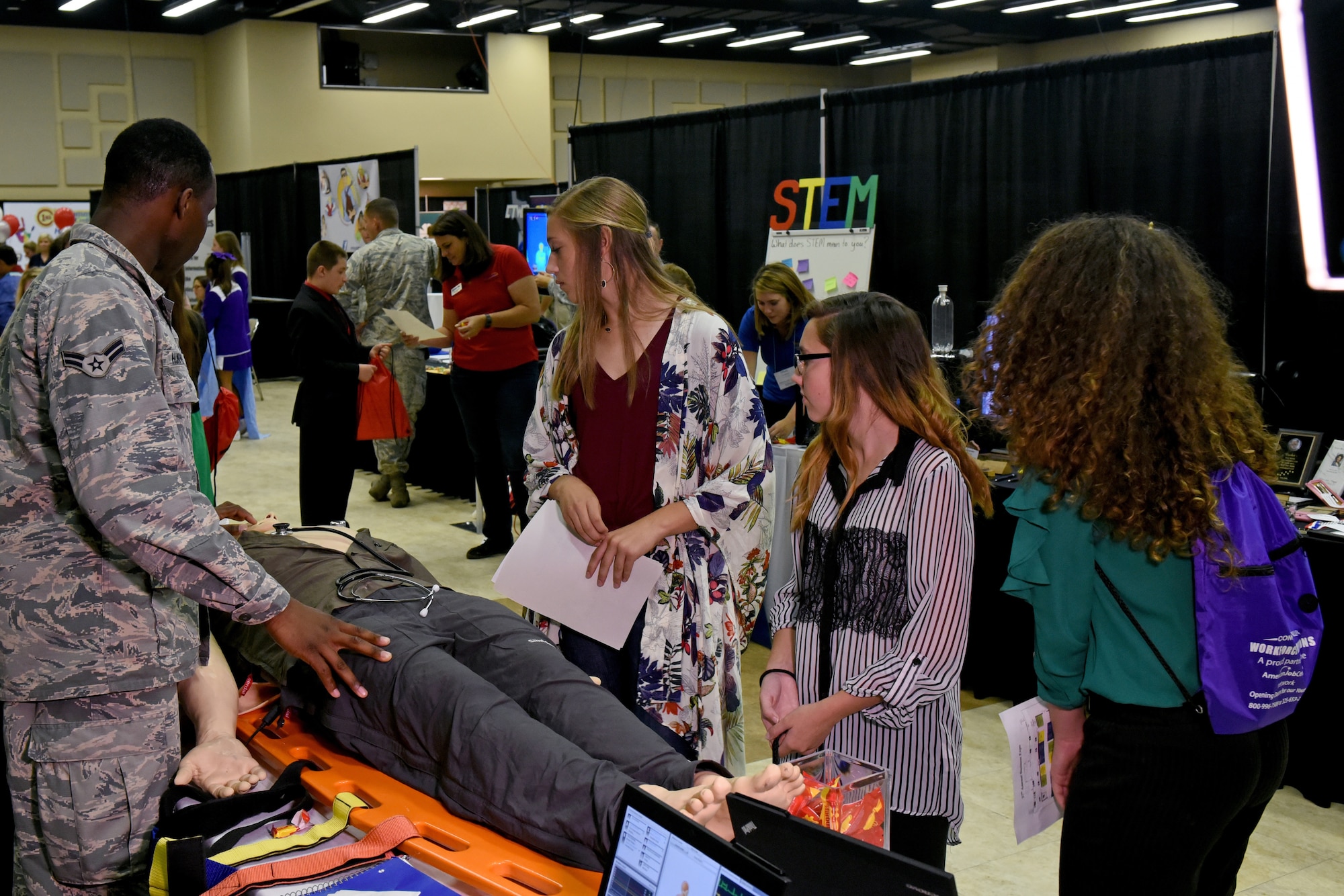 U.S. Air Force Airman 1st Class Marckus Humphries, 17th Medical Group aerospace medical service technician, demonstrates the patient simulator to eighth grade students during the Chamber of Commerce Business Expo at the McNease Convention Center, in San Angelo, Texas, Sept. 27, 2018.  The simulator imitates breathing, heart rate, coughing, and speech. (U.S. Air Force 1st Class Zachary Chapman/Released)