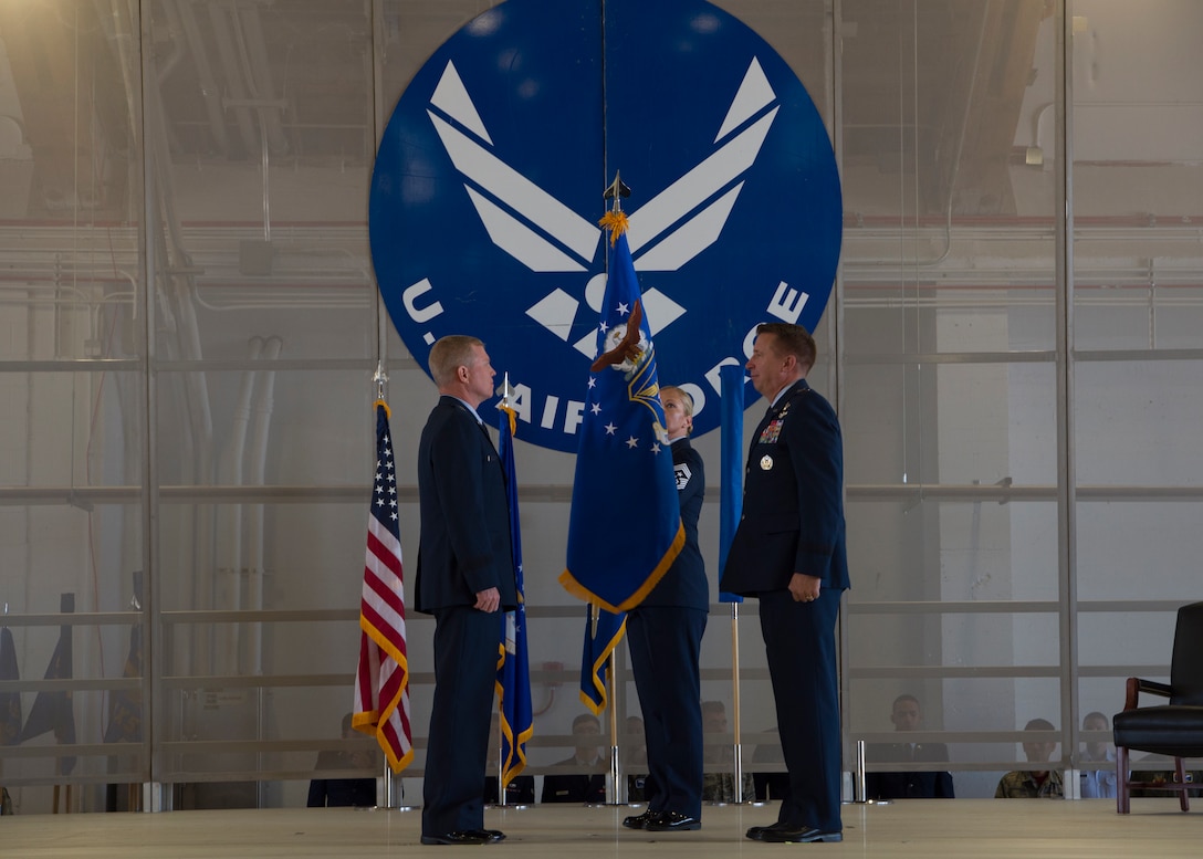 Maj. Gen. Andrew A. Croft, (left) 12th Air Force commander, and Mj. Gen. Patrick Doherty, (right) 19th Air Force commander, stands at attention as Chief Master Sgt. Sarah Esparza, 49th Wing command chief, lowers the Air Combat Command flag Sept. 28, in hangar 301 on Holloman Air Force Base, N.M. The 49th Wing held a ceremony for its transition to Air Education and Training Command. (U.S. Air Force by Airman Autumn Vogt)