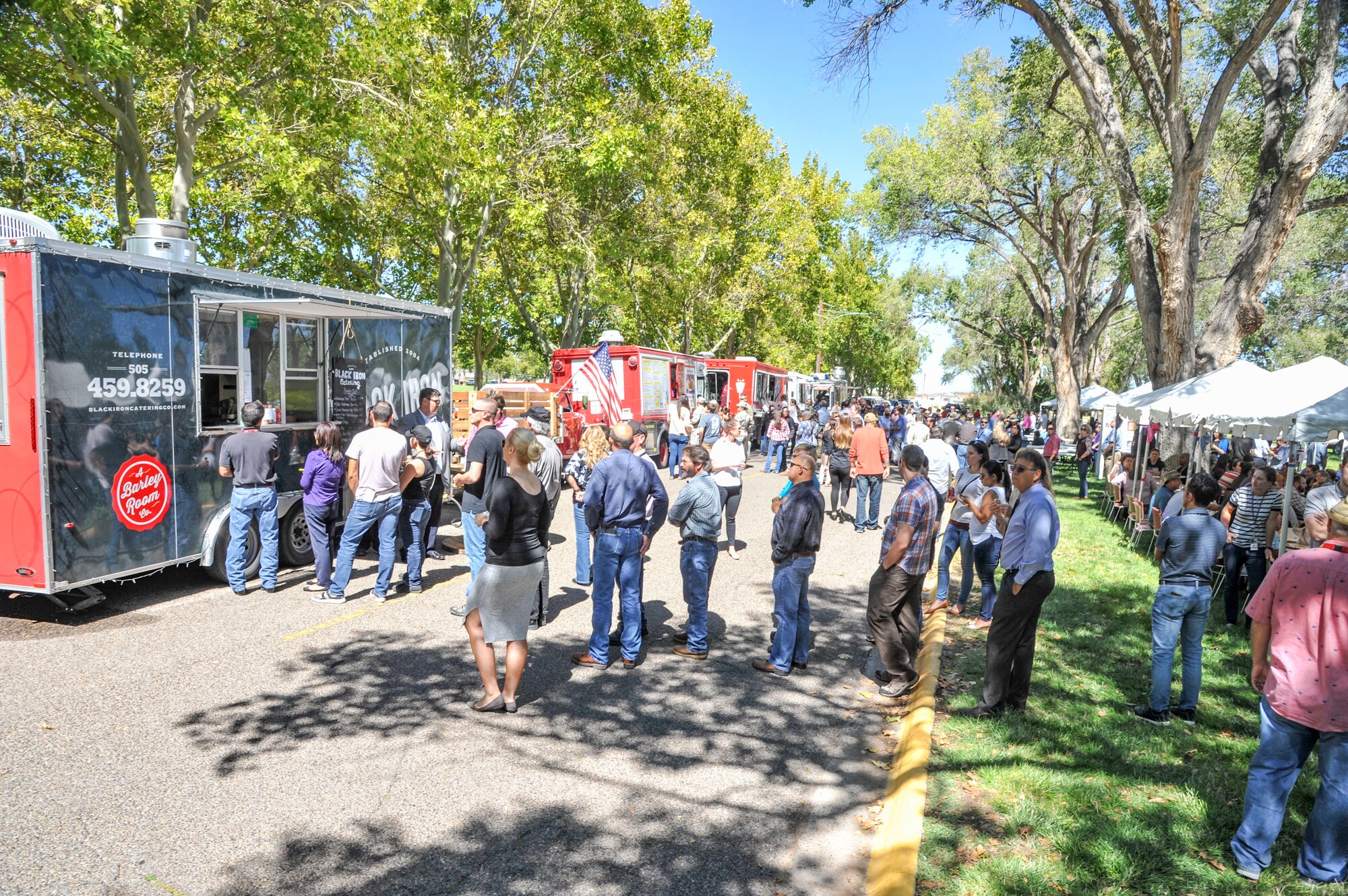 People queue for food trucks at the 2018 Hispanic Heritage Diversity Day event at Hardin Field here Sept. 27. This year's event featured keynote speaker Albuquerque DA Raul Torrez, the Al Hurricane Jr. Band. There was also a car show, an art show, and a samba sizzle Latin dance workout. (U.S. Air Force photo by Jim Fisher)