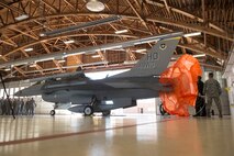 Dedicated crew chiefs from the 314th Aircraft Maintenance Squadron unveil the Air Education and Training Command patch on the 49th Wing fighter jet F-16 Viper during the major command reassignment ceremony Sept. 28, on Holloman Air Force Base, N.M. Transitioning to AETC from Air Combat Command will allow the 49th Wing to more effectively execute their mission of training future F-16 Viper and MQ-9 Reaper pilots and sensor operators. (U.S. Air Force photo by Tech. Sgt Amanda N. Junk)