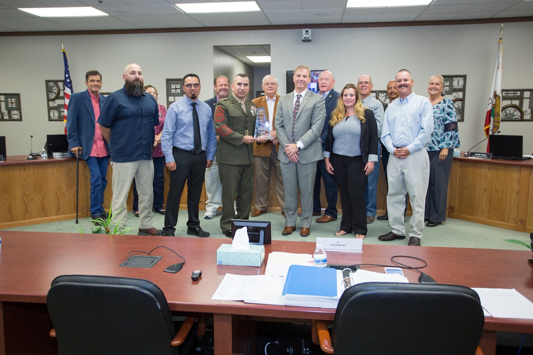 (Front row left) Bo Gonzalez, risk management division director, Production Plant Barstow; Michael Fernandez, Environmental Protection Specialist, base Air Program manager; Sgt. Maj. Sergio MartinezRuiz, base sergeant major; Brad Poiriez, executive director, MDAQMD; May Mamari, Air Quaility Specialist, MDAQMD; and Cody Leslie, base Natural Resources manager, stand with members of the Mojave Desert Air Quality Management District in accepting the Exemplar Award from the district board at their reqular board meeting Sept. 24.