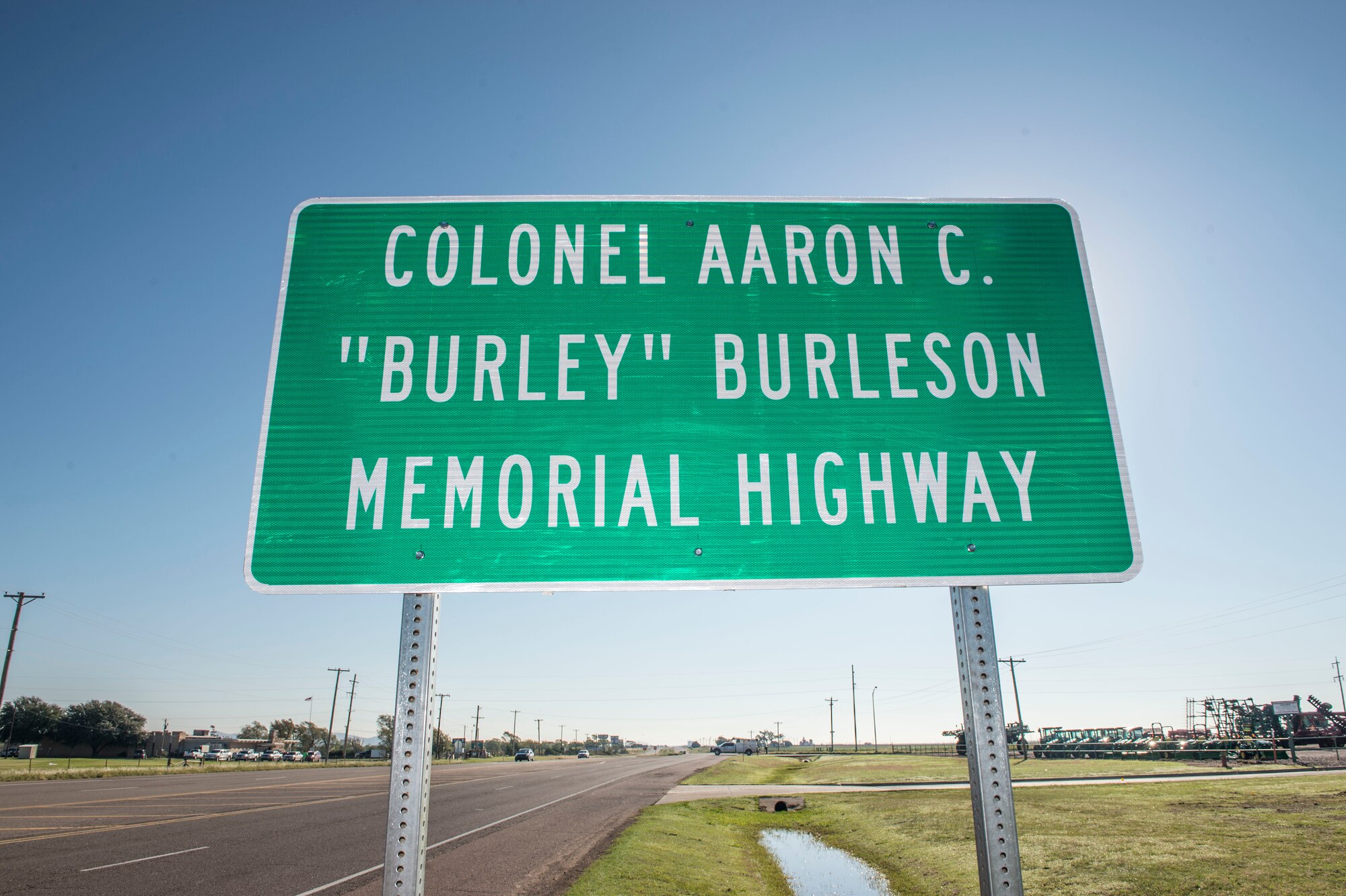A sign is dedicated to the late U.S. Air Force Col. (Ret.) Aaron C. "Burley" Burleson, former commander of the 97th Air Mobility Wing, Sep. 28, 2018, at Altus, Okla. To honor his achievements to the Altus community and 97th AMW, the portion of State Highway 62 beginning at County Road 206 and extending east to County Road 210 in Jackson County was named after him. (U.S. Air Force photo by Senior Airman Cody Dowell)