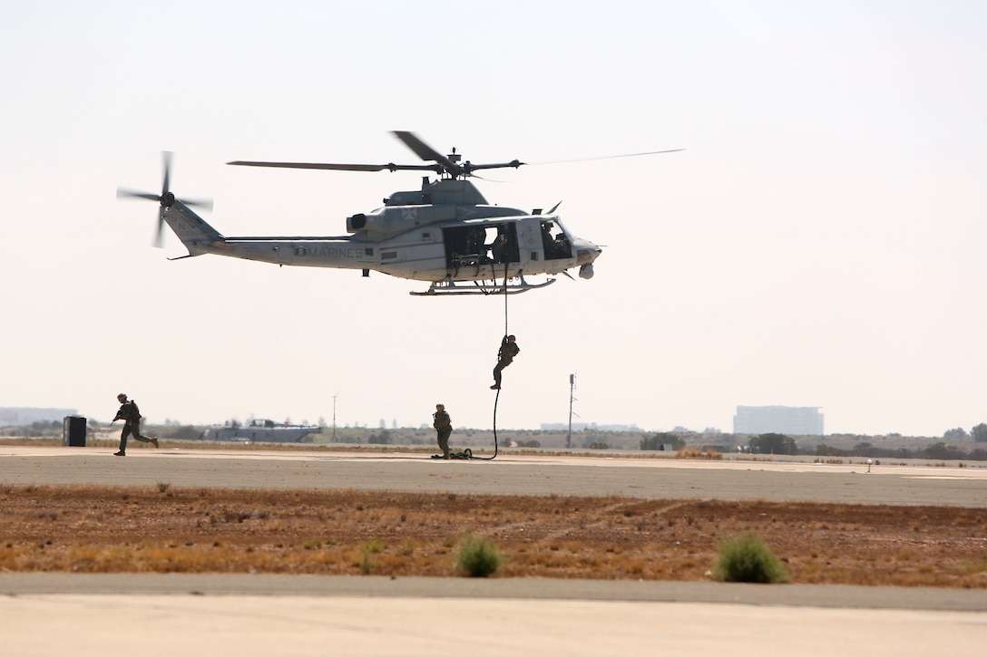U.S. Marines fast rope out of UH-1Y Huey utility helicopter at the Marine Air Ground Task Force demonstration during the Marine Corps Air Station Miramar air show, MCAS Miramar, Calif., Sept. 28 This years air show honors "100 years of women in the Marine Corps" by featuring several performances and displays that highlight accomplishments and milestones women made since the first female enlistee, Olpha May Johnson, who joined the service in 1918. (U.S. Marine Corps photo by Cpl. Joshua S. McAlpine)