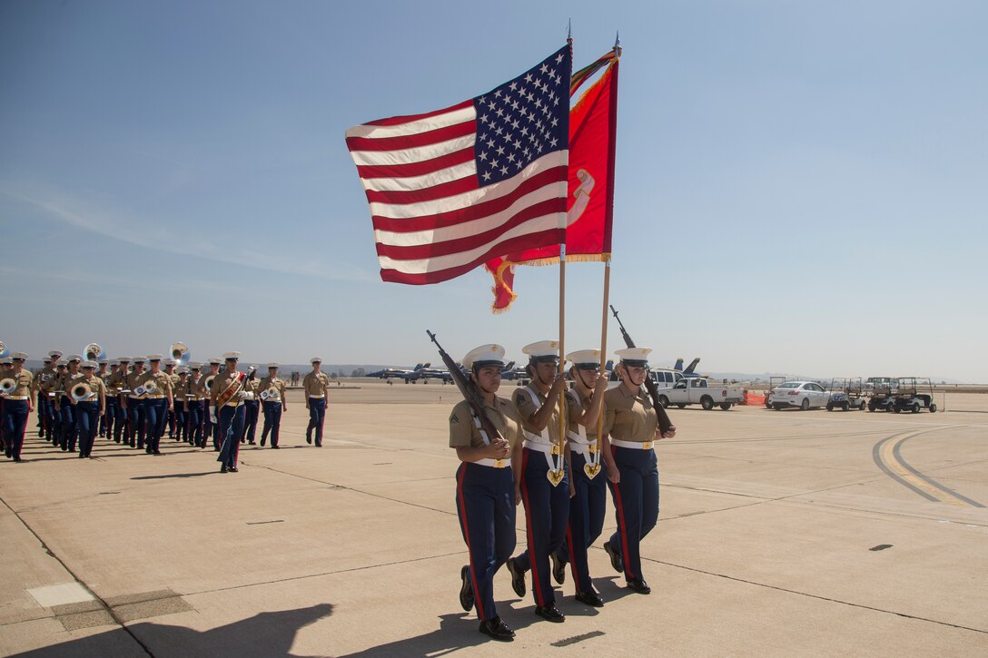 Members of the Headquarters and Headquarters Squadron color guard and 3rd Marine Aircraft Wing Band march on the flight line during the 2018 Marine Corps Air Station Miramar Air Show opening ceremony at MCAS Miramar, Calif., Sept. 28. This years air show honors “100 years if women in the Marine Corps” by featuring several performances and displays that highlight accomplishments and milestones since the first female enlistee, Opha May Johnson, who joined the service in 1918. (U.S. Marine Corps photo by Lance Cpl. Maritza Vela)