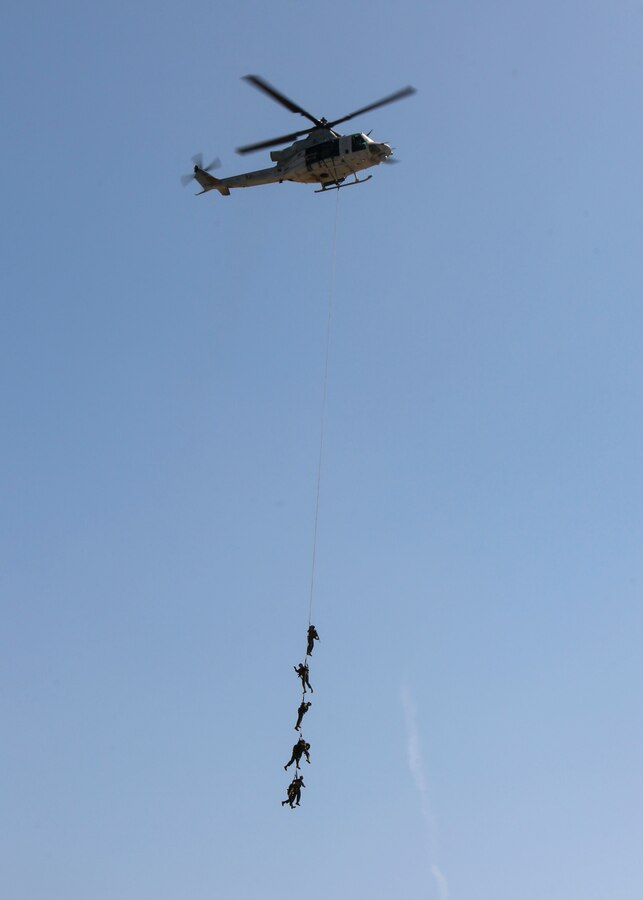 Marines perform special patrol insertion/extraction techniques with Marine Light Attack Helicopter Squadron (HMLA) 169 during the Marine Air-Ground Task Force demonstration during the 2018 Marine Corps Air Station Miramar Air Show at MCAS Miramar, Calif., Sept. 28. This year's air show honors "100 years of women in the Marine Corps" by featuring several performances and displays that highlight accomplishments and milestones women made since the first female enlistee, Opha May Johnson, who joined the service in 1918. (U.S. Marine Corps photo by Cpl. Joshua S. McAlpine)