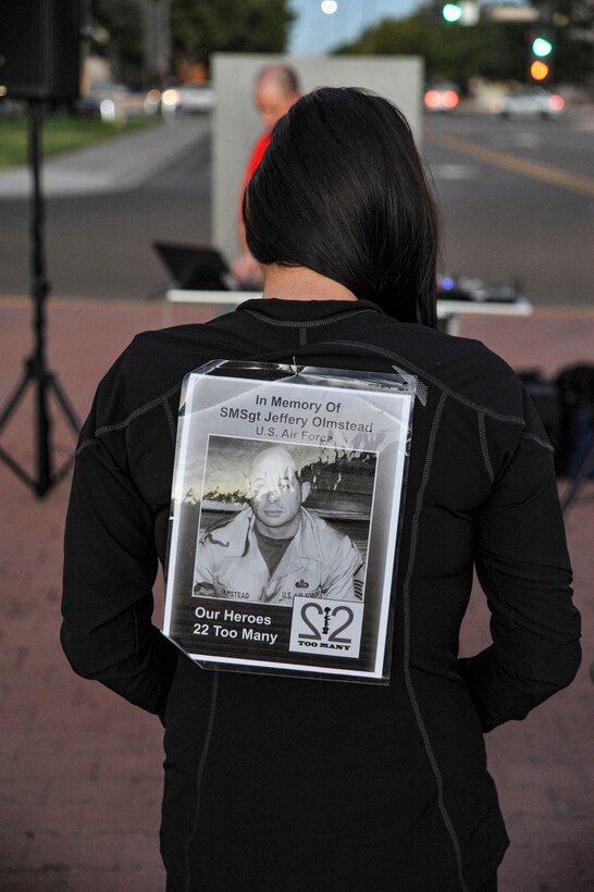 Stephanie Olmstead displays a picture of her father Senior Master Sgt. Jeffery Olmstead, whom she lost to suicide in 2017, prior to the "We won't back down" Suicide Prevention run/walk Sept. 28 at Hardin Field. (U.S. Air Force photo by Jim Fisher)