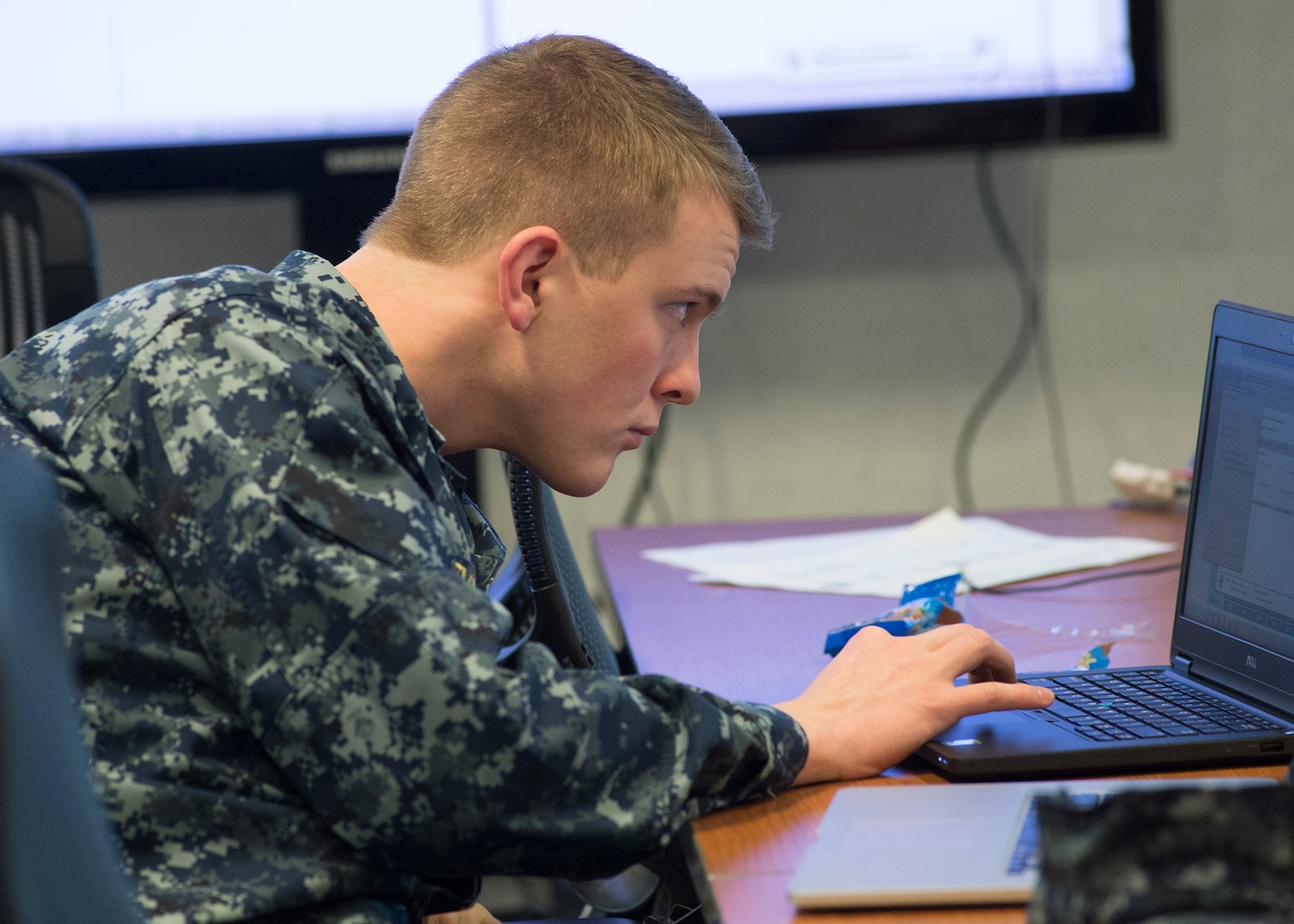 A member of the Red Cell studies his computer screen intently as he challenges participants' cyber defense  skills.