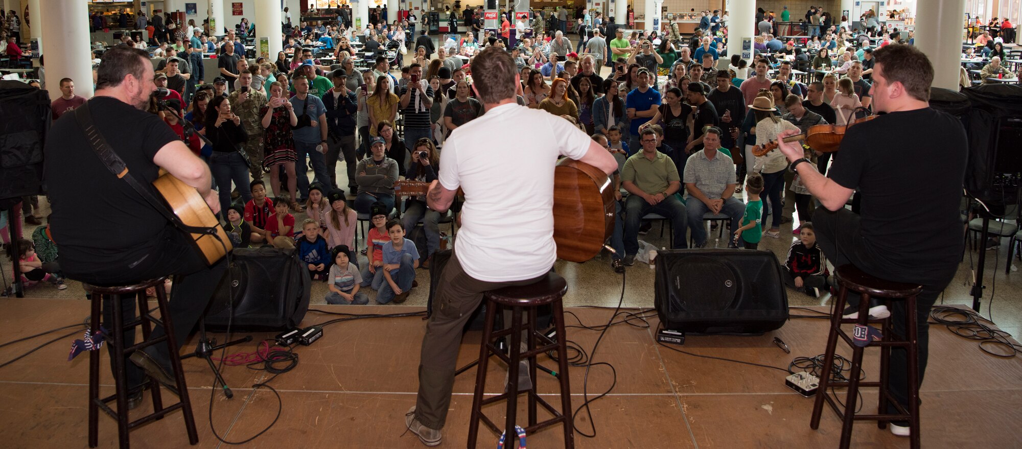 (Center) Craig Morgan, U.S. Army veteran and country music singer and songwriter, performs on stage with his music group in front of U.S. service members and their families as part of the USO Spring Visit on Ramstein Air Base, Germany, March 30, 2019.