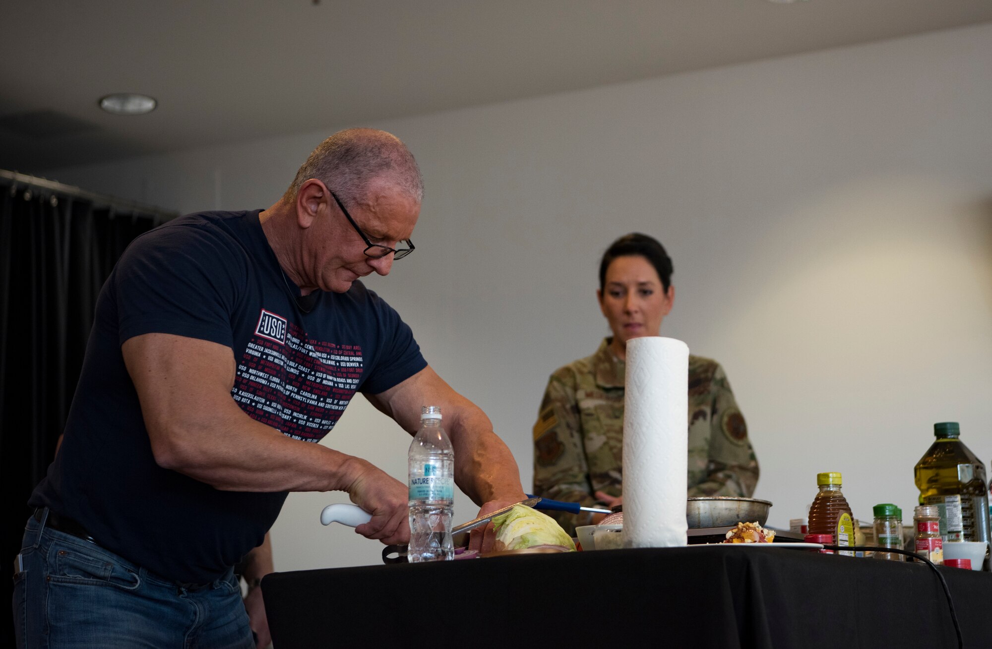 Robert Irvine, celebrity chef, attempts to make a meal from start to finish before a member of the audience completes 100 push-ups on Ramstein Air Base, Germany, March 30, 2019.