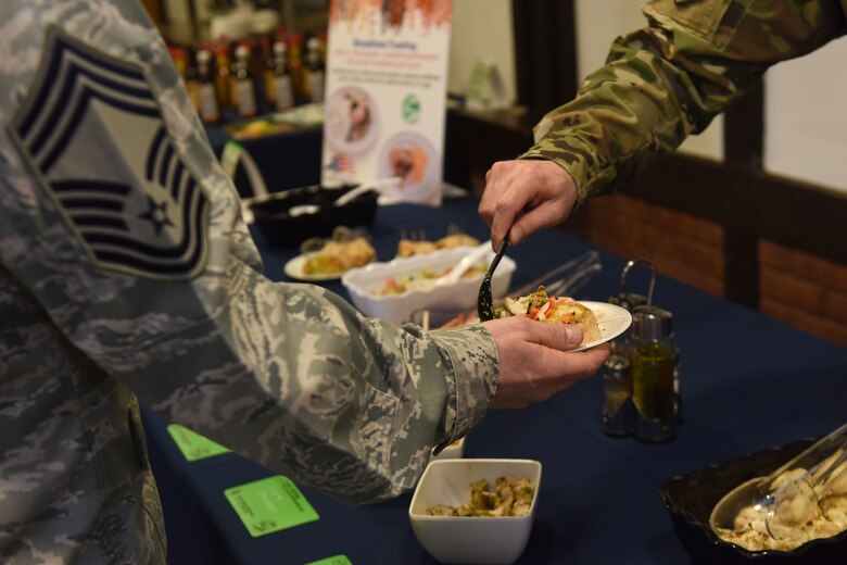 An Airman serves samples of the new ‘Go for Green 2.0’ meals during a pre-opening for G4G 2.0 at the Knight’s Table dining facility at Royal Air Force Lakenheath, England, March 22, 2019. The nutrition initiative is intended to be more robust, combining multiple approaches to provide a greater performance-enhancing culinary atmosphere for dining facility customers. (U.S. Air Force photo by Airman 1st Class Madeline Herzog)