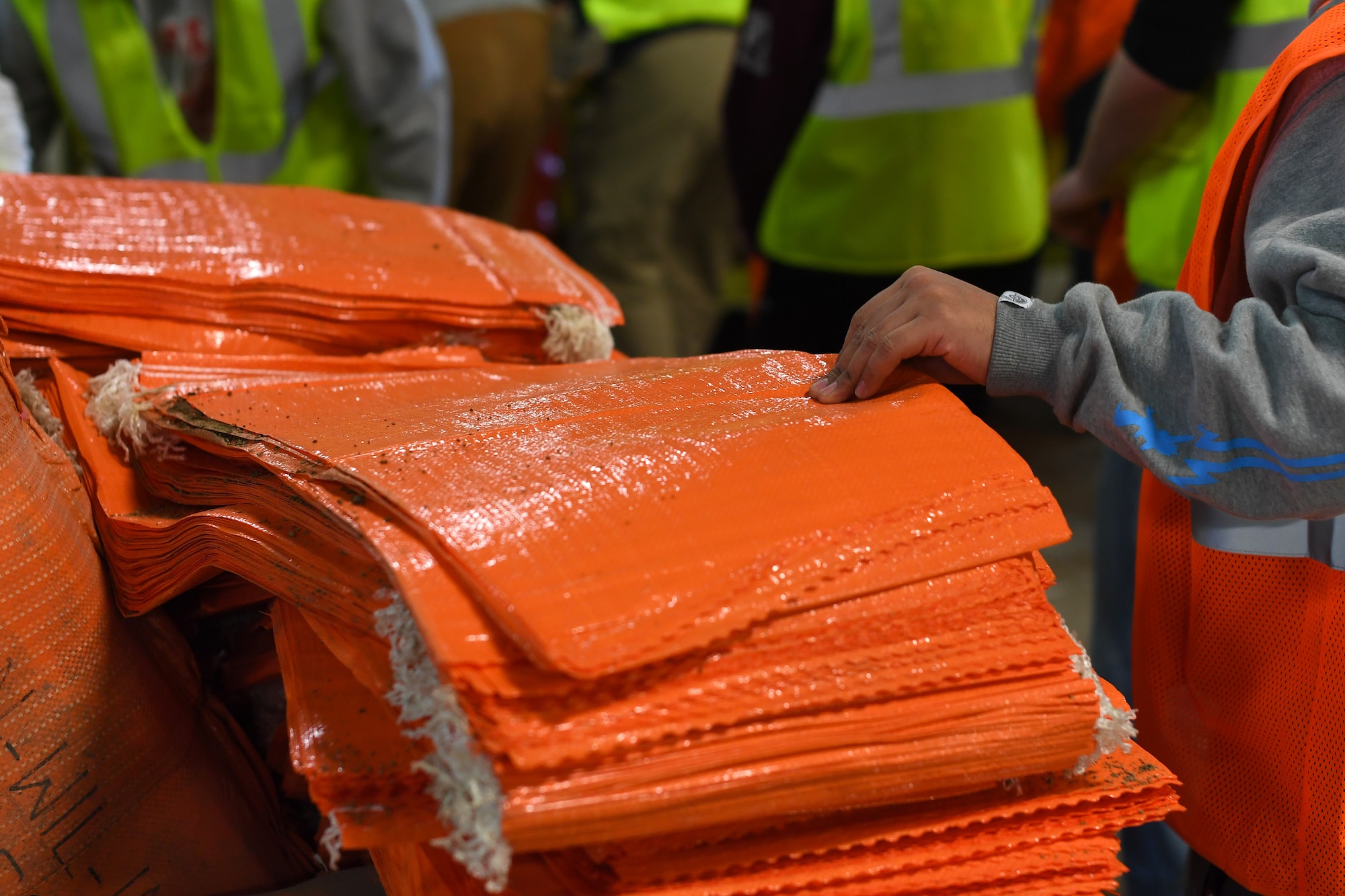 A Grand Forks Air Force Base member grabs an empty bag to begin filling with sand during a sandbag stockpile volunteer event March 28, 2019, in Grand Forks, North Dakota. Nearly 60 Grand Forks AFB members assisted with creating 10,000 sandbags to prepare for a potential springtime flood thought to affect Grand Forks. (U.S. Air Force photo by Senior Airman Elora J. Martinez)