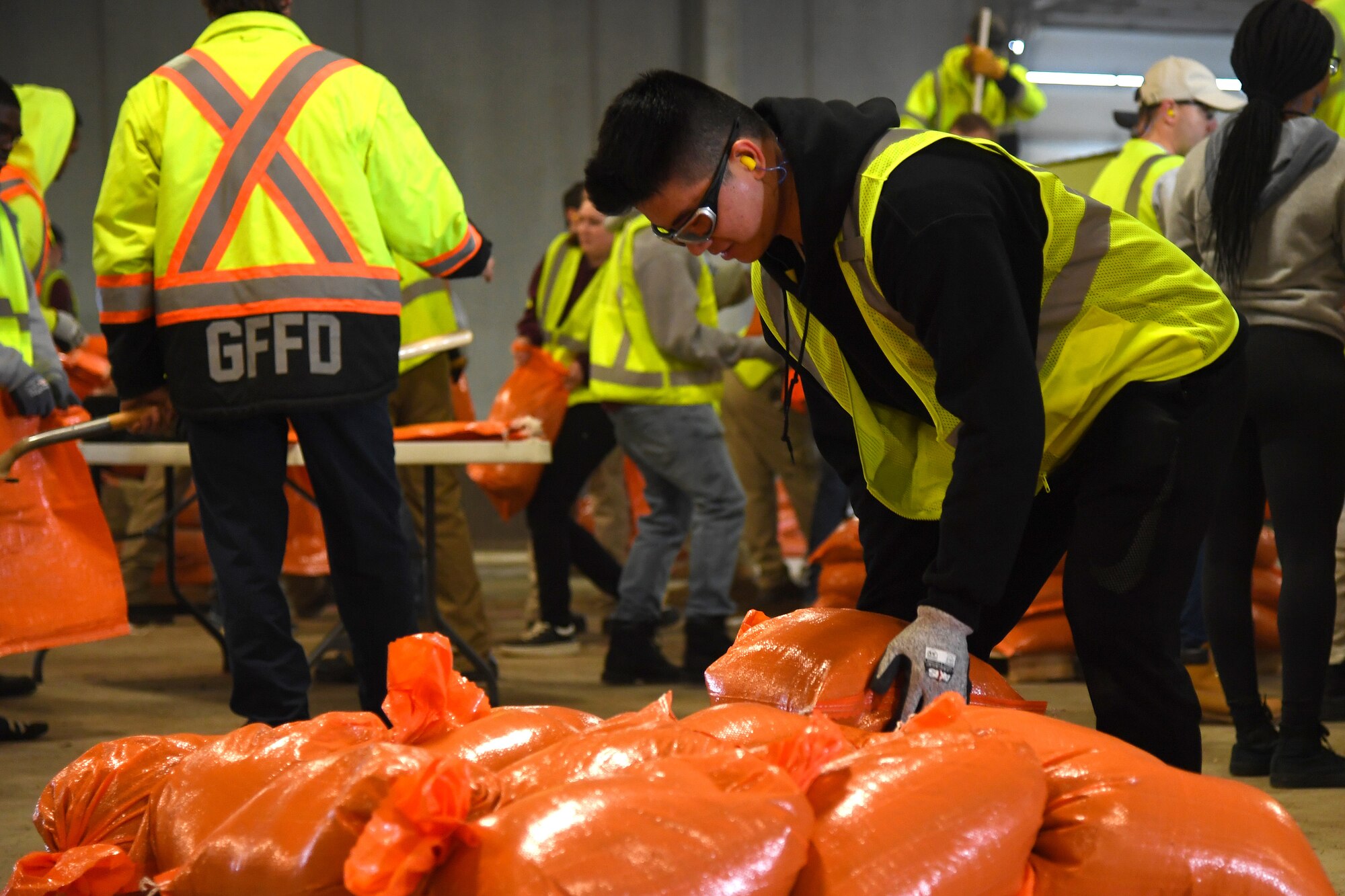 Airman 1st Class Ninghui Fang, 319th Force Support Squadron food services apprentice, stacks a completed sandbag onto a pallet during a sandbag stockpile volunteer event March 28, 2019, in Grand Forks, North Dakota. Nearly 60 Grand Forks Air Force Base members worked together to fill several thousand sandbags in preparation of expected flooding. (U.S. Air Force photo by Senior Airman Elora J. Martinez)