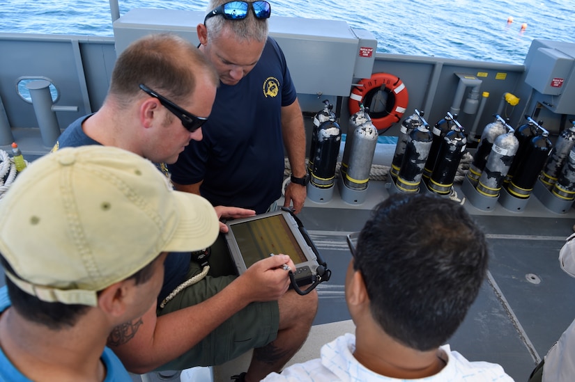 Force Master Diver Scott Brodeur, Naval Expeditionary Combat Command, watches as Chief Navy Diver Marshall Goble tries out the Office of Naval Research TechSolutions-sponsored Scuba Binary Dive Application during a demonstration and evaluation off the coast of Panama City, Fla.