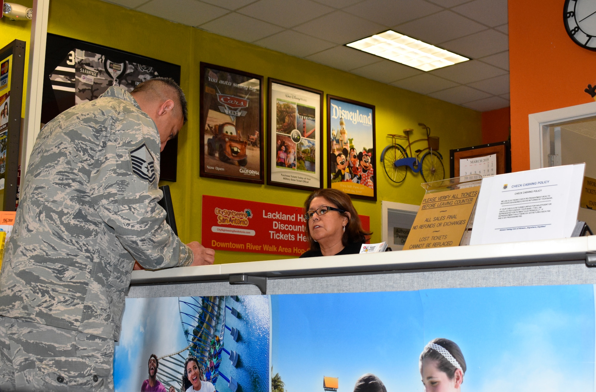 Diana Gonzalez, a sales associate at Joint Base San Antonio-Lackland's Information, Tickets and Travel office helps Master Sgt. Juan Rodriguez select seats for a sporting event. (U.S. Air Force photo by Debbie Aragon)