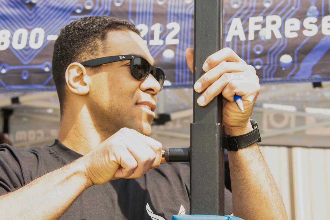 U.S. Air Force Tech. Sgt. Jason Castillo adjust the pull-up bar at his booth during Peabody Magnet High School's Junior ROTC Fund Day March 28, 2019 in Alexandria, Louisiana.  Castillo was just one of several 307th Bomb Wing recruiters canvassing the city at multiple events throughout the day.    (U.S. Air Force photo by Master Sgt. Ted Daigle)