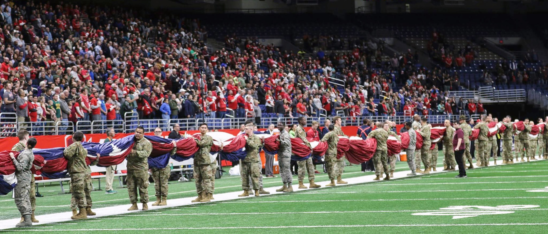 To honor military members past and present, service members from across Joint Base San Antonio, as well as ROTC cadets from the University of Texas at San Antonio, presented the American flag during the National Anthem at the San Antonio Commanders football game at the Alamodome in downtown San Antonio March 31. More than 100 Service members and cadets participated in the flag-holding ceremony to open Sunday's game.