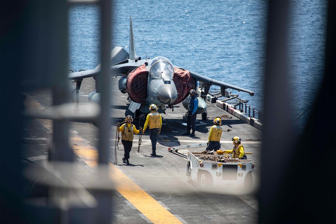 Service members prepare to move an aircraft.