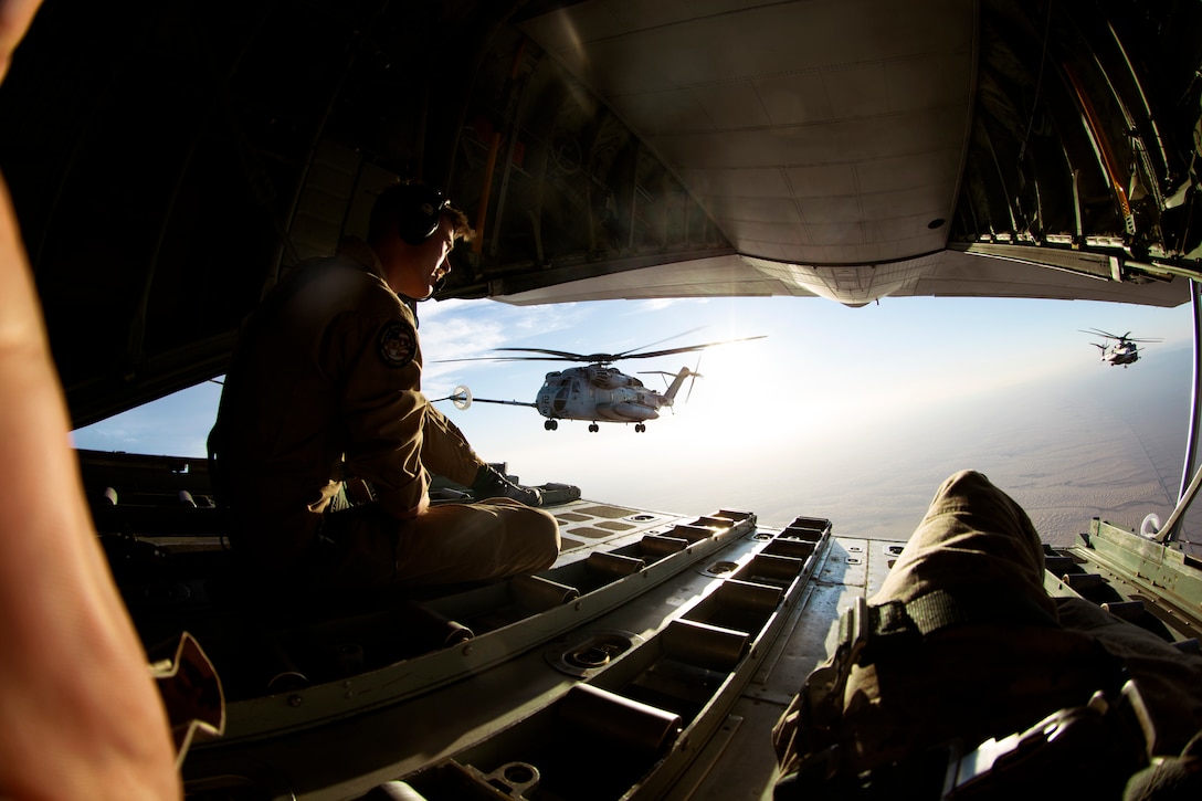 Cpl. Dylan Frank, a crew master with Marine Aerial Refueler Transport Squadron 152, watches as two U.S. Marine Corps CH-53E Super Stallion aircraft assigned to Marine Aviation Weapons and Tactics Squadron One perform a high altitude aerial refuel in support of Weapons and Tactics Instructor course 2-19 in Yuma, Arizona, March 27, 2019. WTI is a seven-week training event hosted by MAWTS-1, which emphasizes operational integration of the six functions of Marine Corps aviation in support of a Marine Air Ground Task Force. WTI also provides standardized advanced tactical training and certification of unit instructor qualifications to support Marine aviation training readiness and assists in developing and employing aviation weapons and tactics.