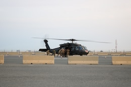 Soldiers retrieve mock casualty from a UH-60 Black Hawk helicopter during the Golden Trident mass casualty training exercise at Camp Arifjan, Kuwait, March 21, 2019.