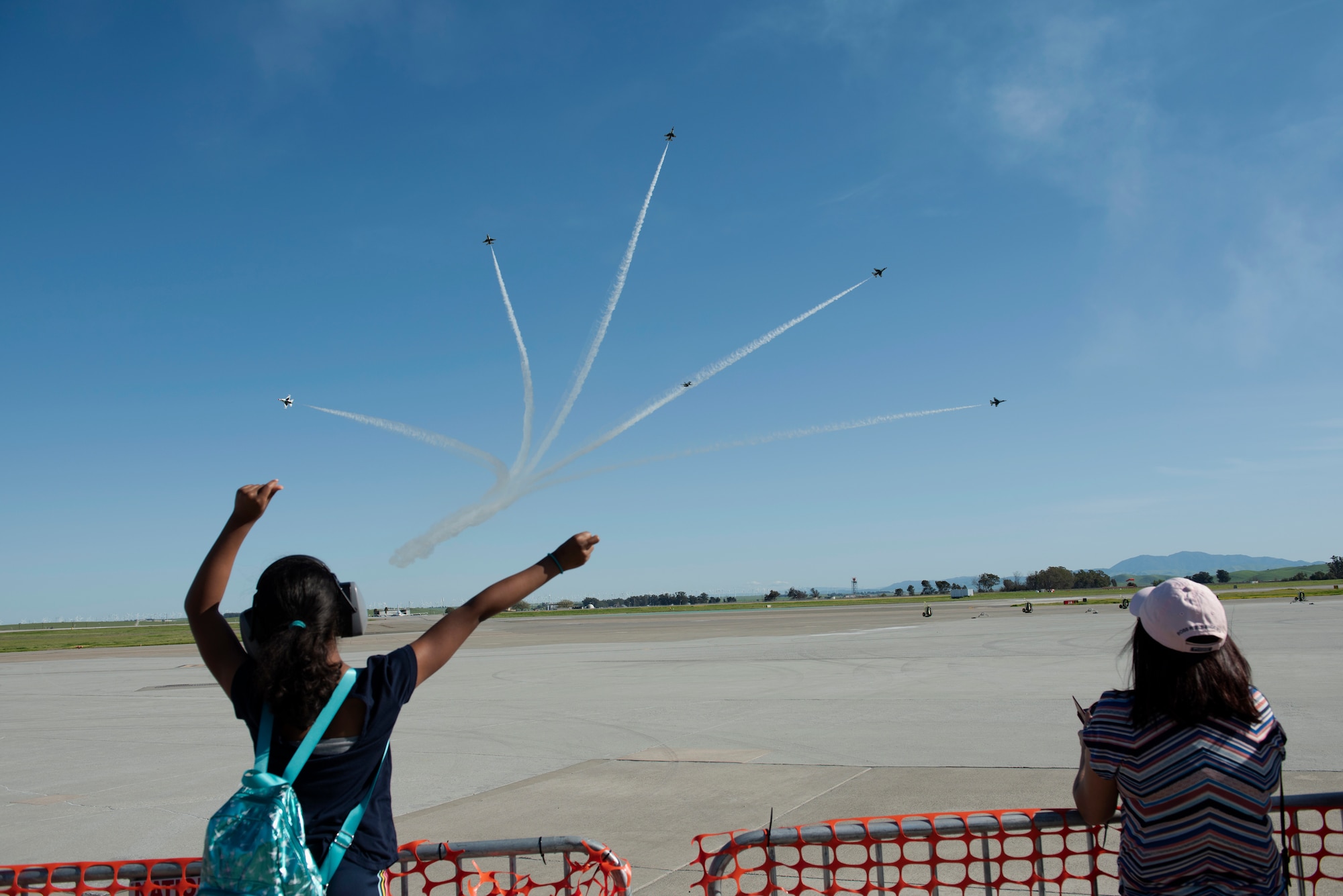 Amani Hodgman, 11, the daughter of Tech. Sgt. James Hodgman, 60th Air Mobility Wing photojournalist, cheers on the U.S. Air Force Thunderbirds aerial demonstration team during the Thunder Over the Bay air show March 30, 2019 at Travis Air Force Base, Calif. The show also featured performances by the F-22 Raptor Demo Team and the U.S. Army Golden Knights, as well as 40 static displays. The event honored hometown heroes like police officers, firefighters, nurses, teachers and ordinary citizens whose selfless work made their communities safer and enhanced the quality of life. (U.S. Air Force photo by Tech. Sgt. James Hodgman)