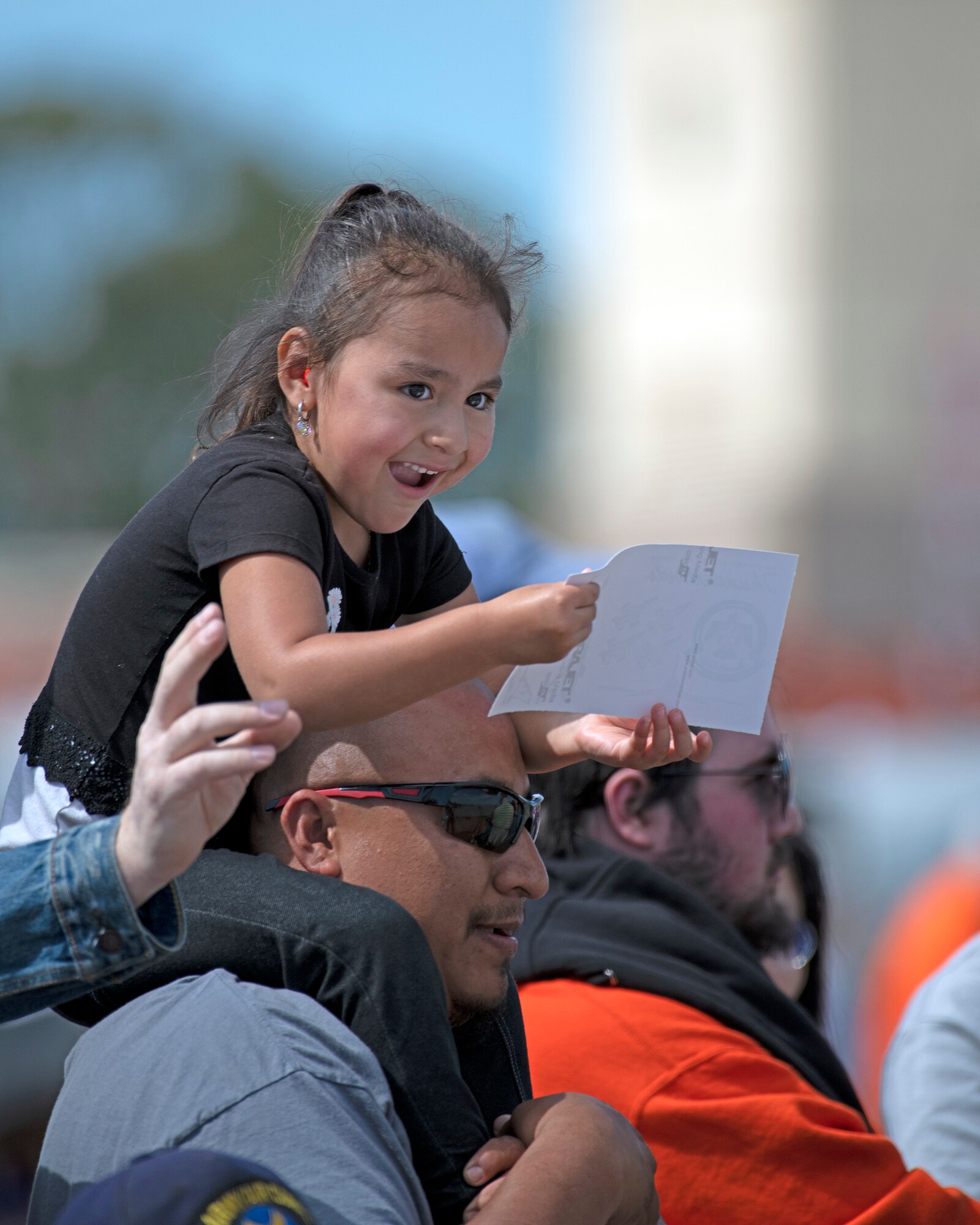 A girl gets a souvenir from USAF Thunderbirds demonstration team during the “Thunder over the Bay” Air Show, Travis Air Force Base, California, March 31, 2019. In addition to the U.S. Air Force Thunderbirds aerial demonstration team, the two-day event featured performances by the U.S. Army Golden Knights parachute team, flyovers, and static displays. The event honored hometown heroes like police officers, firefighters, nurses, teachers and ordinary citizens whose selfless work made their communities safer and enhanced the quality of life. (U.S. Air Force photo by Louis Briscese)
