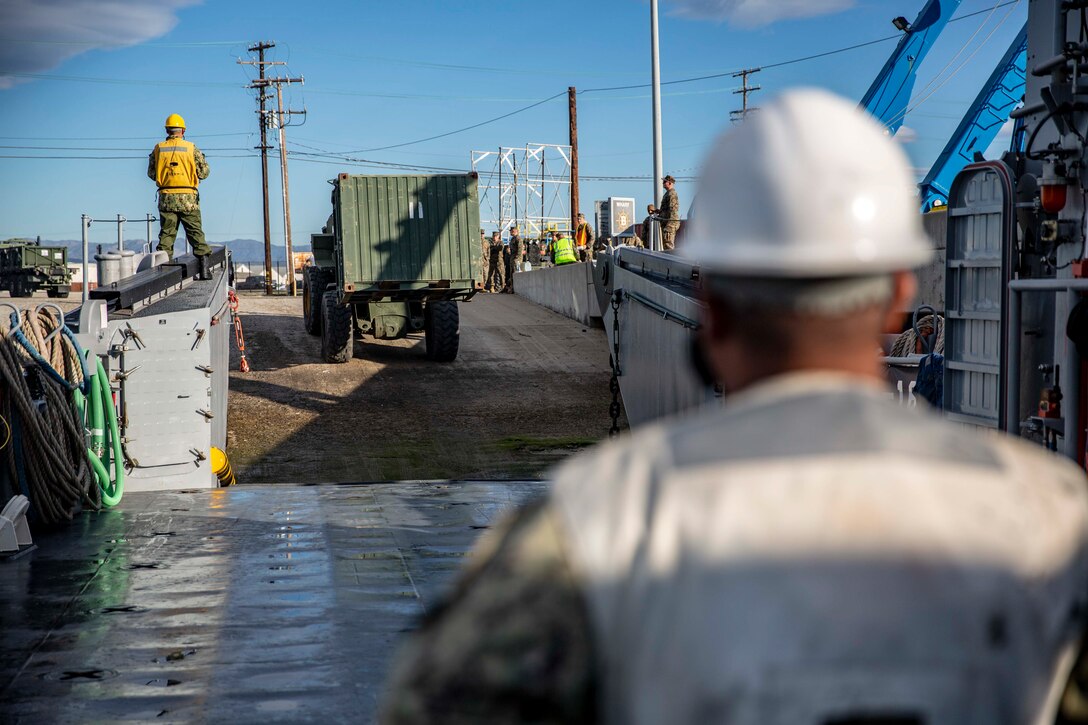 U.S. Sailors guide a Tractor, Rubber-tired, Articulated Steering, Multi-Purpose (TRAM) hauling a freight container onto a Landing Craft Utility during maritime movement operations at Port Hueneme, Calif., as part of Exercise Pacific Blitz 19, March 12. PacBlitz19 is designed to train Marines and Sailors in maritime prepositioning force operations and aims to increase proficiency, expand levels of cooperation and to enhance maritime capabilities. (U.S. Marine Corps photo by Cpl. Jacob A. Farbo)