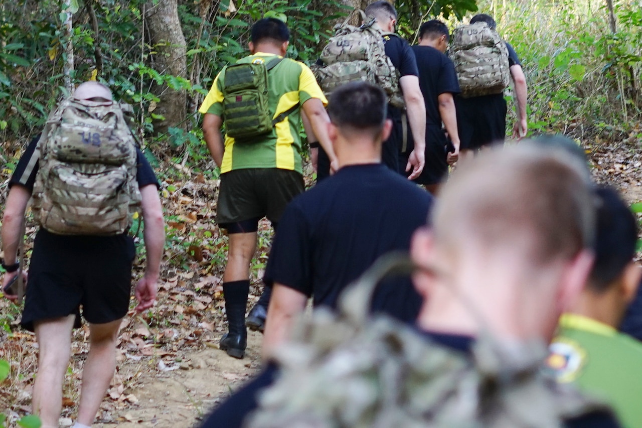Troops hike jungle trail
