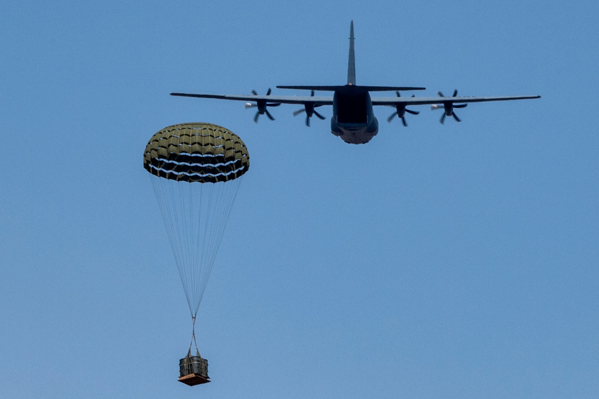A parachute opens as a bundle floats toward the ground