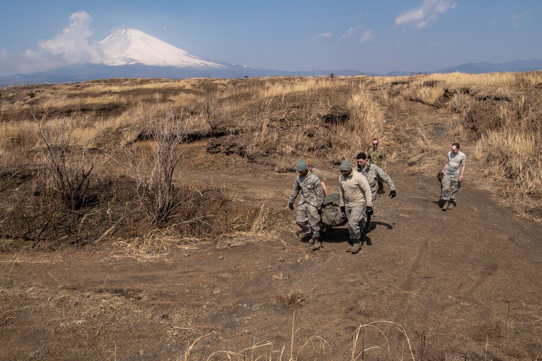 Airmen with the 374th Logistics Readiness Squadron carry the recovery bag